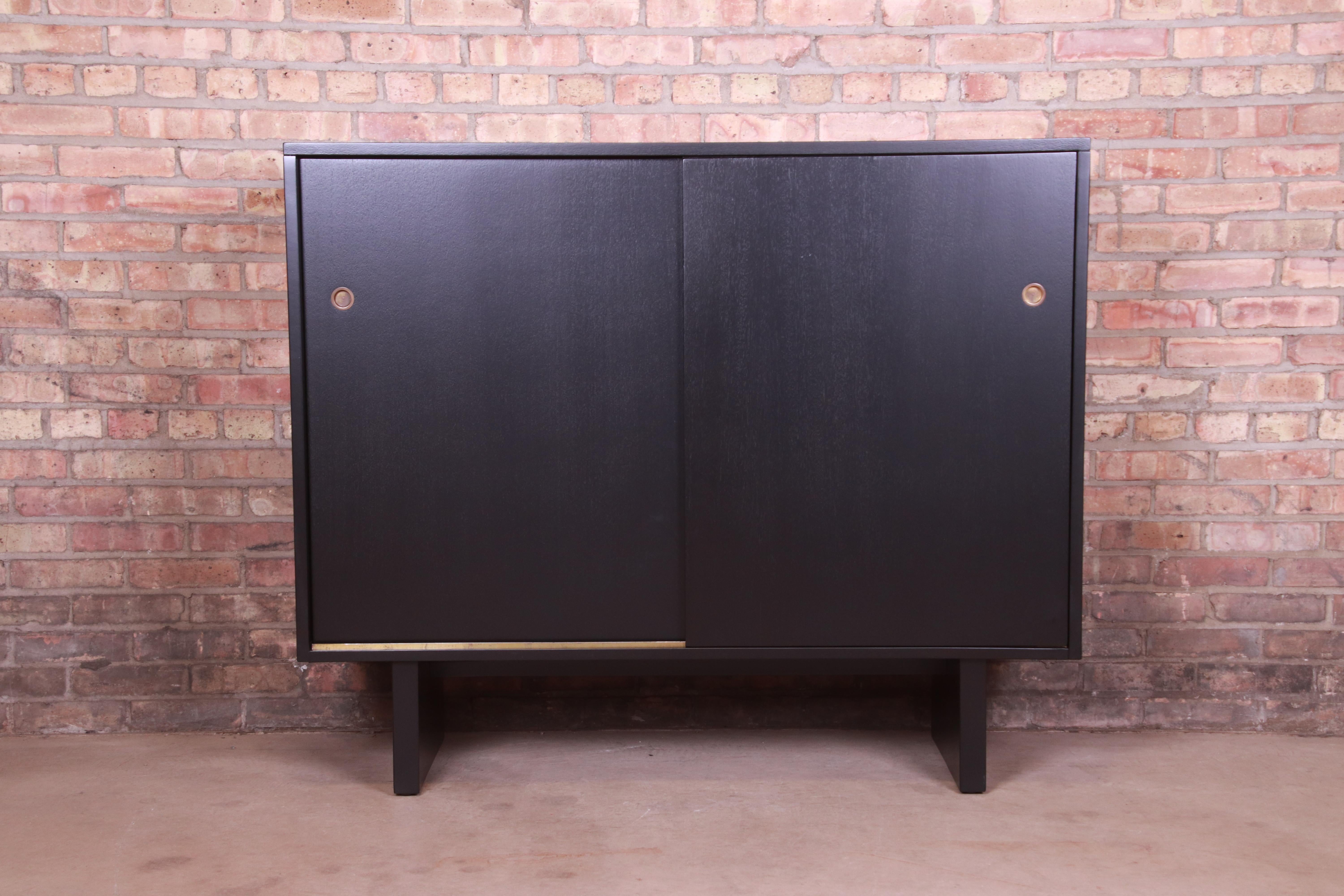 An exceptional Mid-Century Modern sliding door gentleman's chest

By T.H. Robsjohn-Gibbings for Widdicomb (Retailed by John Stuart, Inc.)

USA, 1950s

Black lacquered walnut, with original brass hardware.

Measures: 51.5