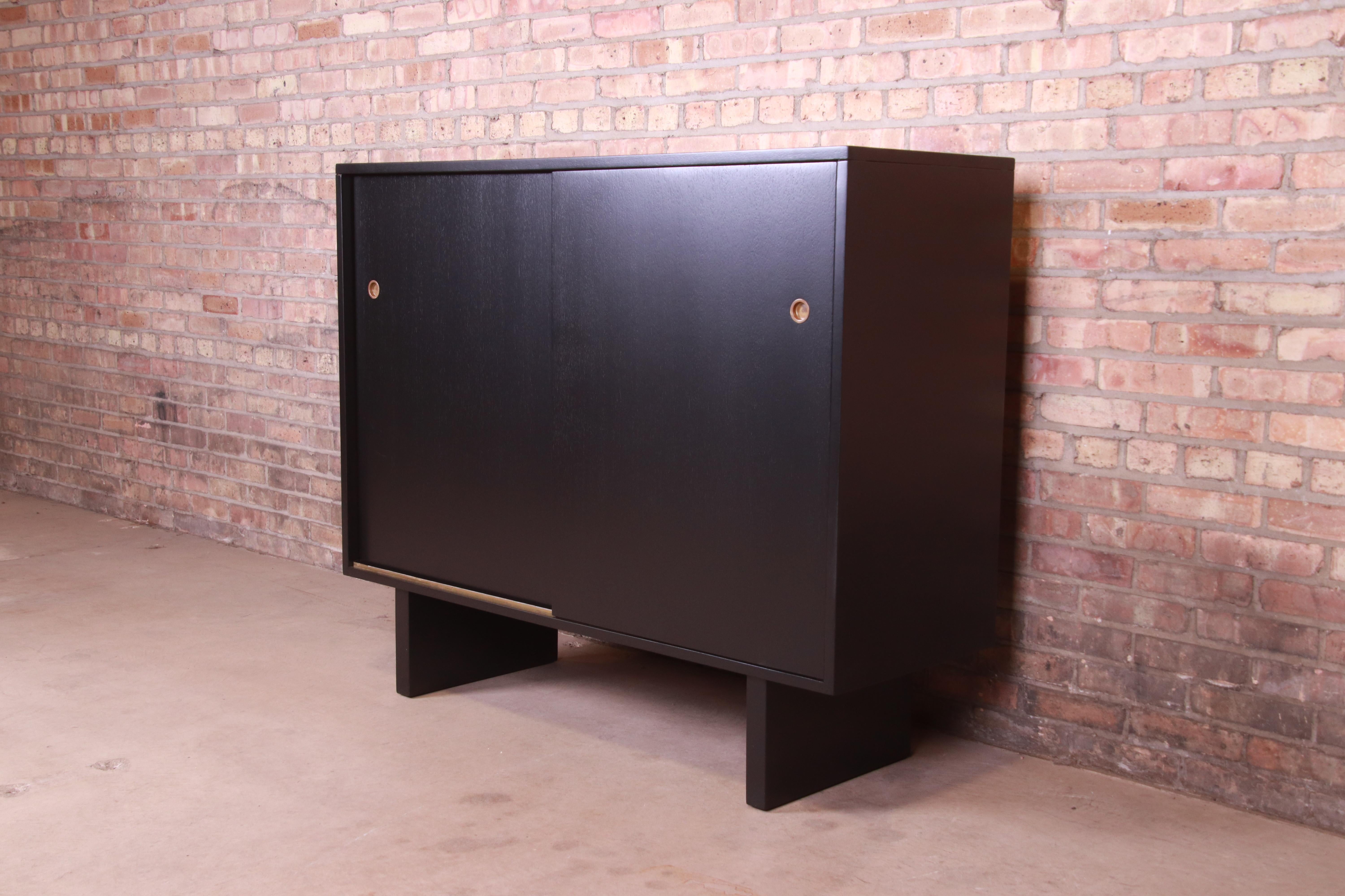 An exceptional Mid-Century Modern sliding door gentleman's chest

By T.H. Robsjohn-Gibbings for Widdicomb (Retailed by John Stuart, Inc.)

USA, 1950s

Black lacquered walnut, with original brass hardware.

Measures: 51.5