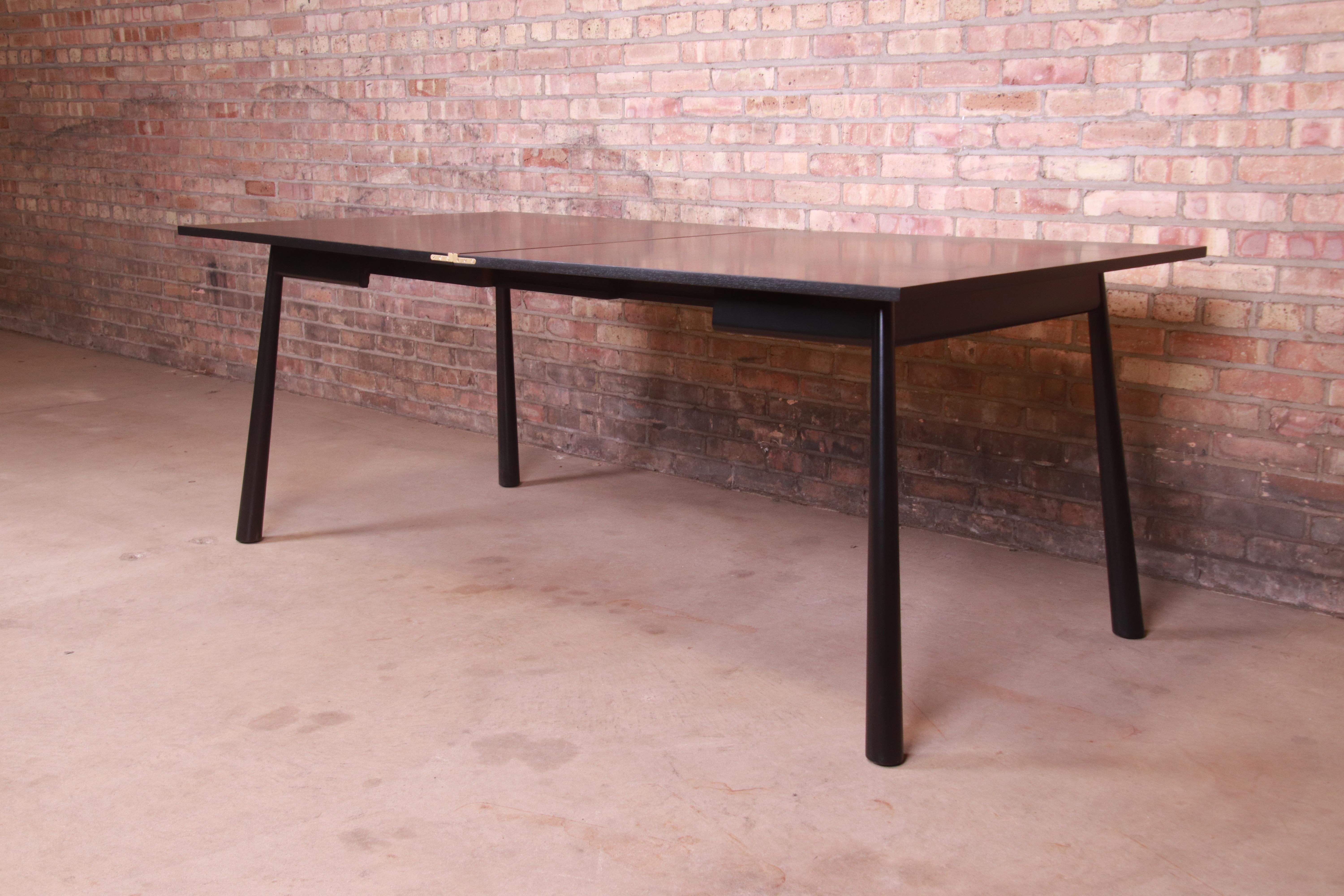 An exceptional Mid-Century Modern flip top dining table or game table

By T.H. Robsjohn-Gibbings for Widdicomb

USA, 1950s

Black lacquered walnut, with original brass hardware.

Measures: 38