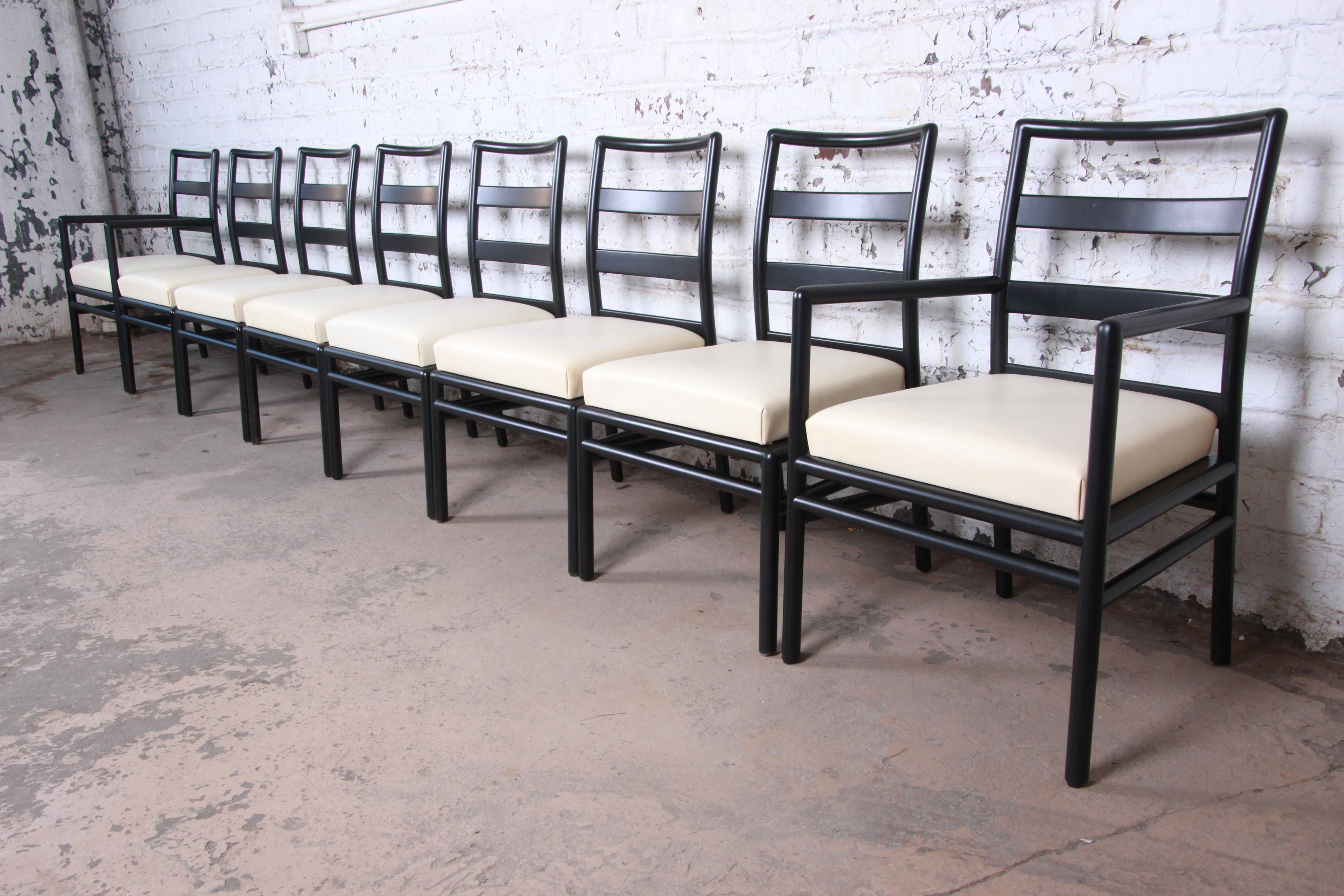 An outstanding set of eight Mid-Century Modern dining chairs designed by T.H. Robsjohn-Gibbings for Widdicomb. The set includes two captain armchairs and six side chairs. The chairs feature a Minimalist ladder back design, with black lacquered
