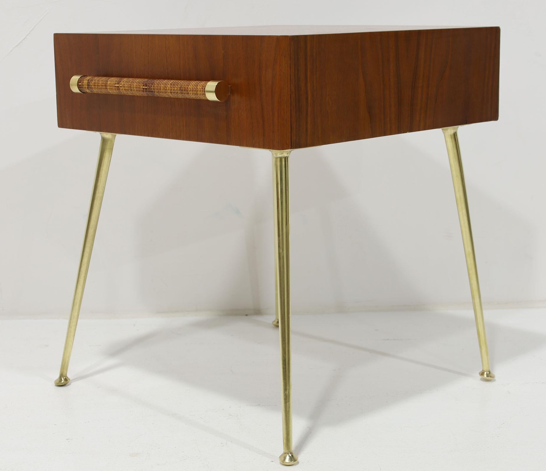 A Mid-Century Modern side cabinet by T.H. Robsjohn-Gibbings for Widdicomb. Walnut with cane wrapped handles and brass legs. Circa 1950. Sometimes used as a side table or a nightstand. 