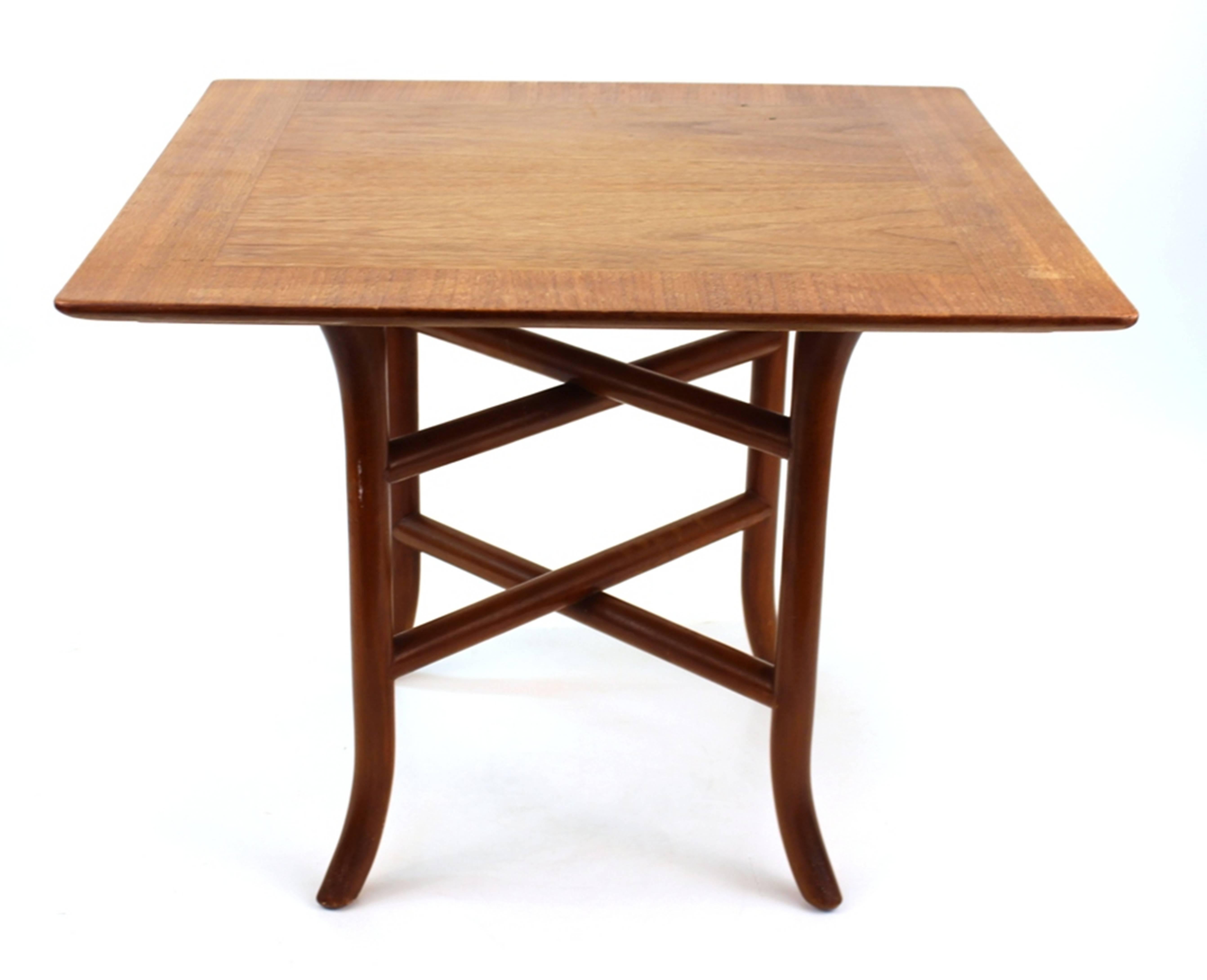 T.H. Robsjohn-Gibbings side table for Widdicomb. Produced with a square top seated on four legs with curved bases. Features two pairs of crossed trestles in between the table legs. Includes the original Widdicomb label and serial number stamps