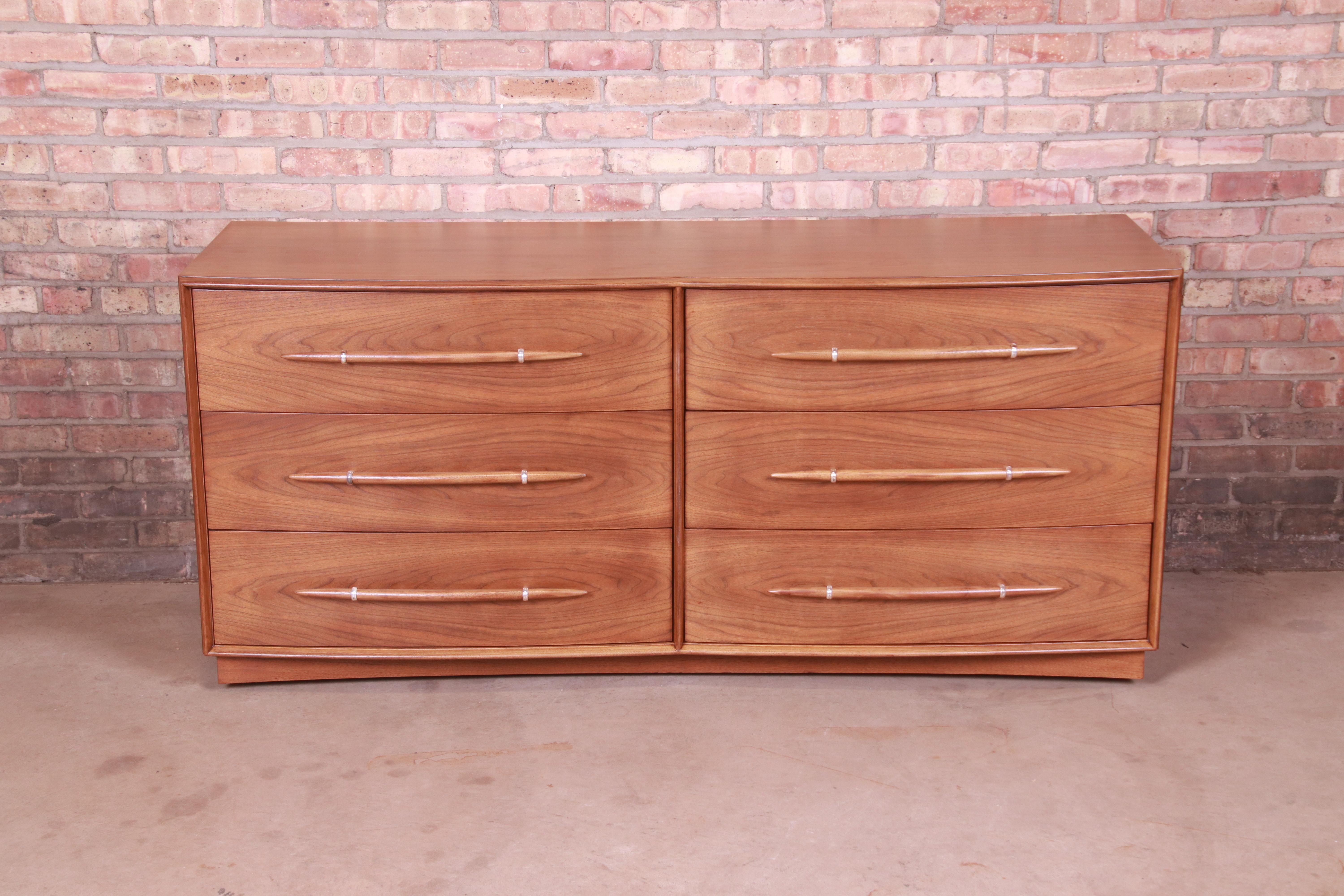 A gorgeous Mid-Century Modern double dresser or credenza

By T.H. Robsjohn-Gibbings for Widdicomb

USA, 1950s

Book-matched walnut, with unique spear-shaped drawer pulls.

Measures: 67