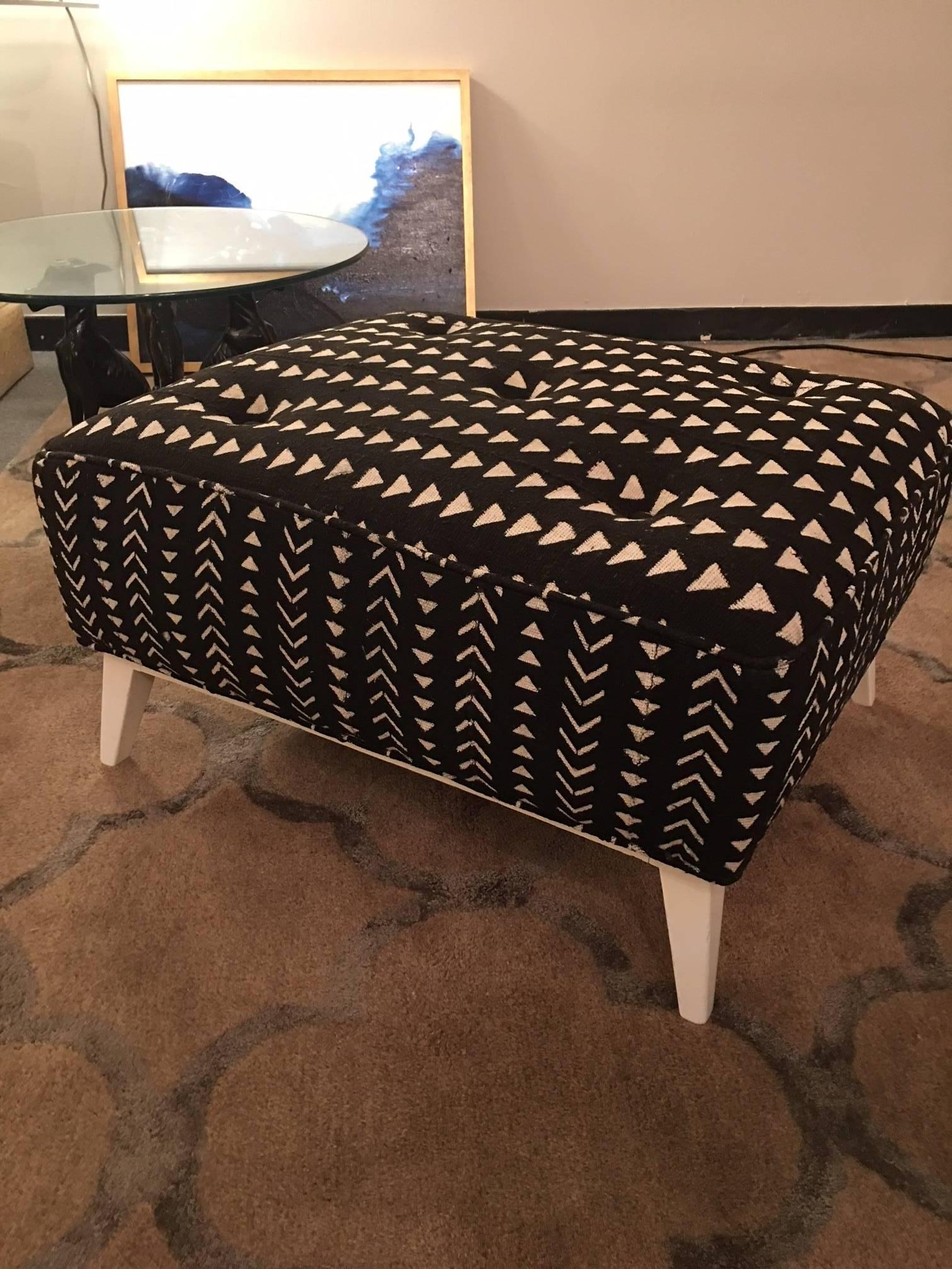 This midcentury ottoman by Robsjohn-Gibbings has been given a facelift with lacquered legs and wonderful mud cloth woven fabric from Africa in black and cream making this a one-of-a-kind piece to grace your eclectic interior.