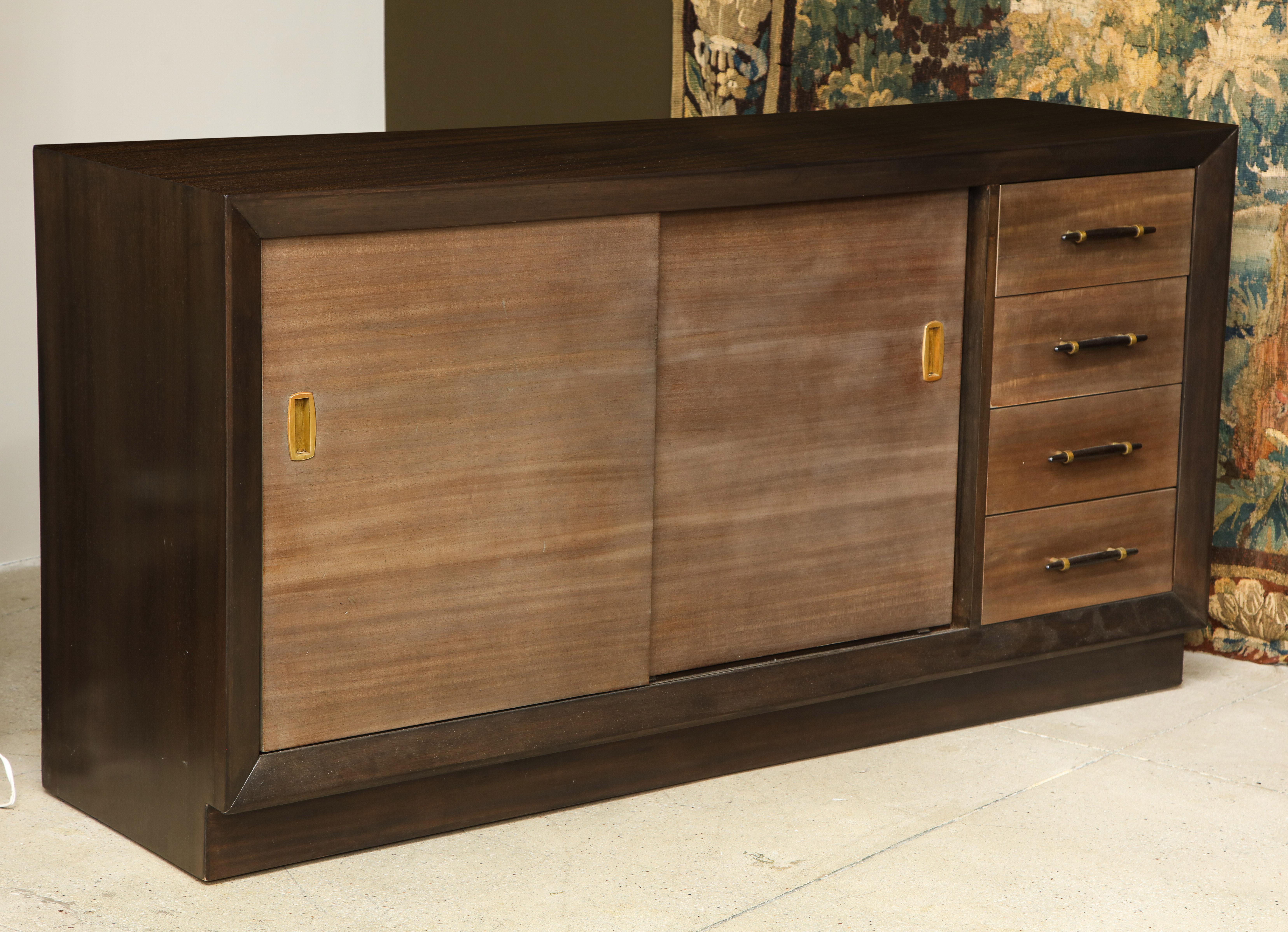 Dark walnut finished long dresser with sliding doors in a paler faun finish circa 1950. Interior cabinet drawer fronts also in the faun finish. 