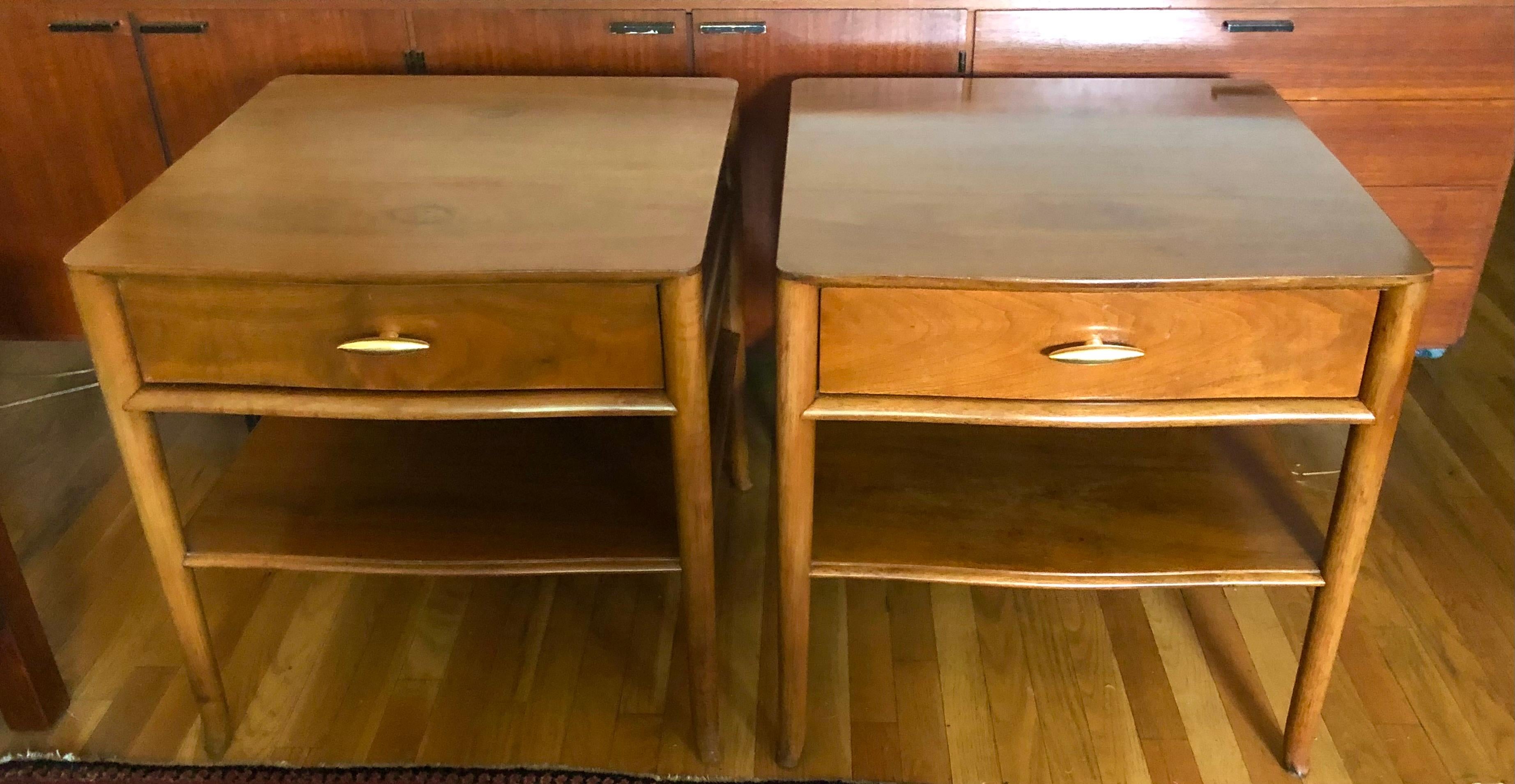 c. 1955, American, these handsome shaped squarish two-tiered tables each have a single drawer and wonderfully figured old growth walnut veneer. The versatile size make these perfect for end tables or nightstands. Finished on the back to allow