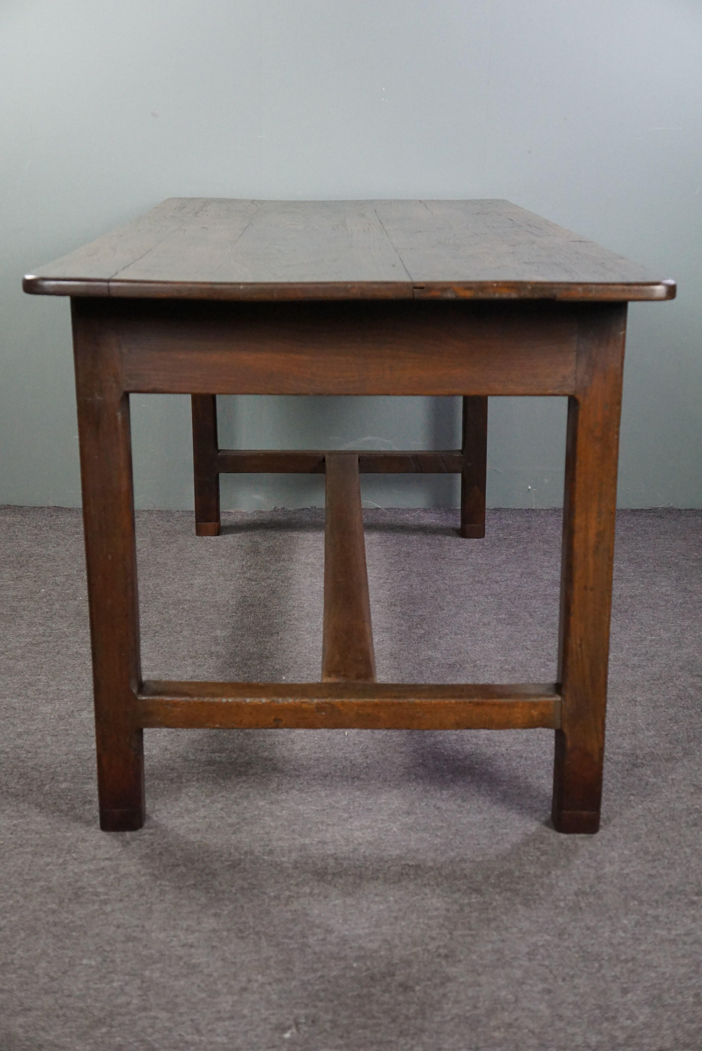 Offered is this robust antique French dining table made of oakwood at the beginning of the 18th century. This beautiful, pure antique dining table has a fantastic robust appearance and fits perfectly into both modern and classic interiors. You can