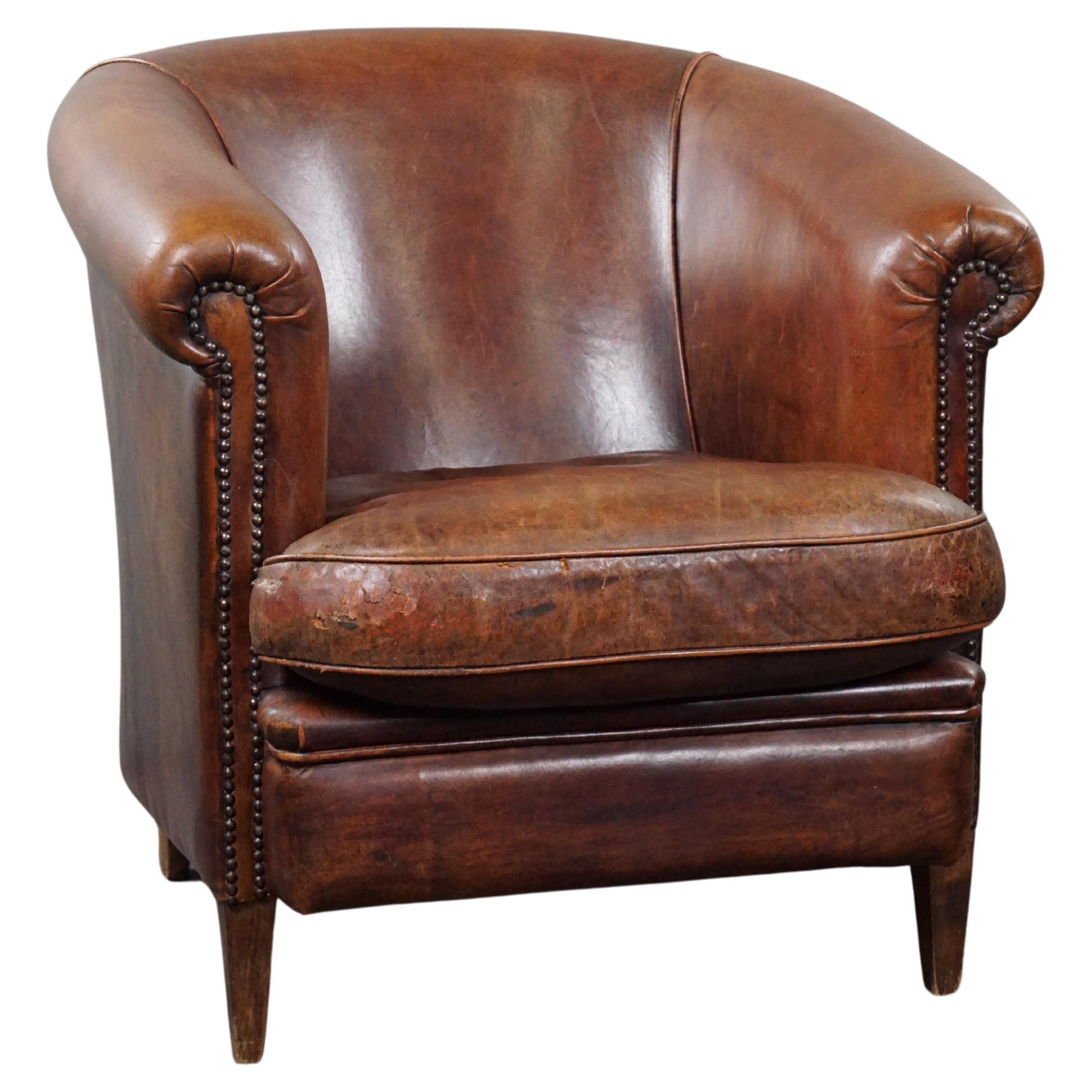 Robust sheep leather club armchair finished with decorative studs For Sale