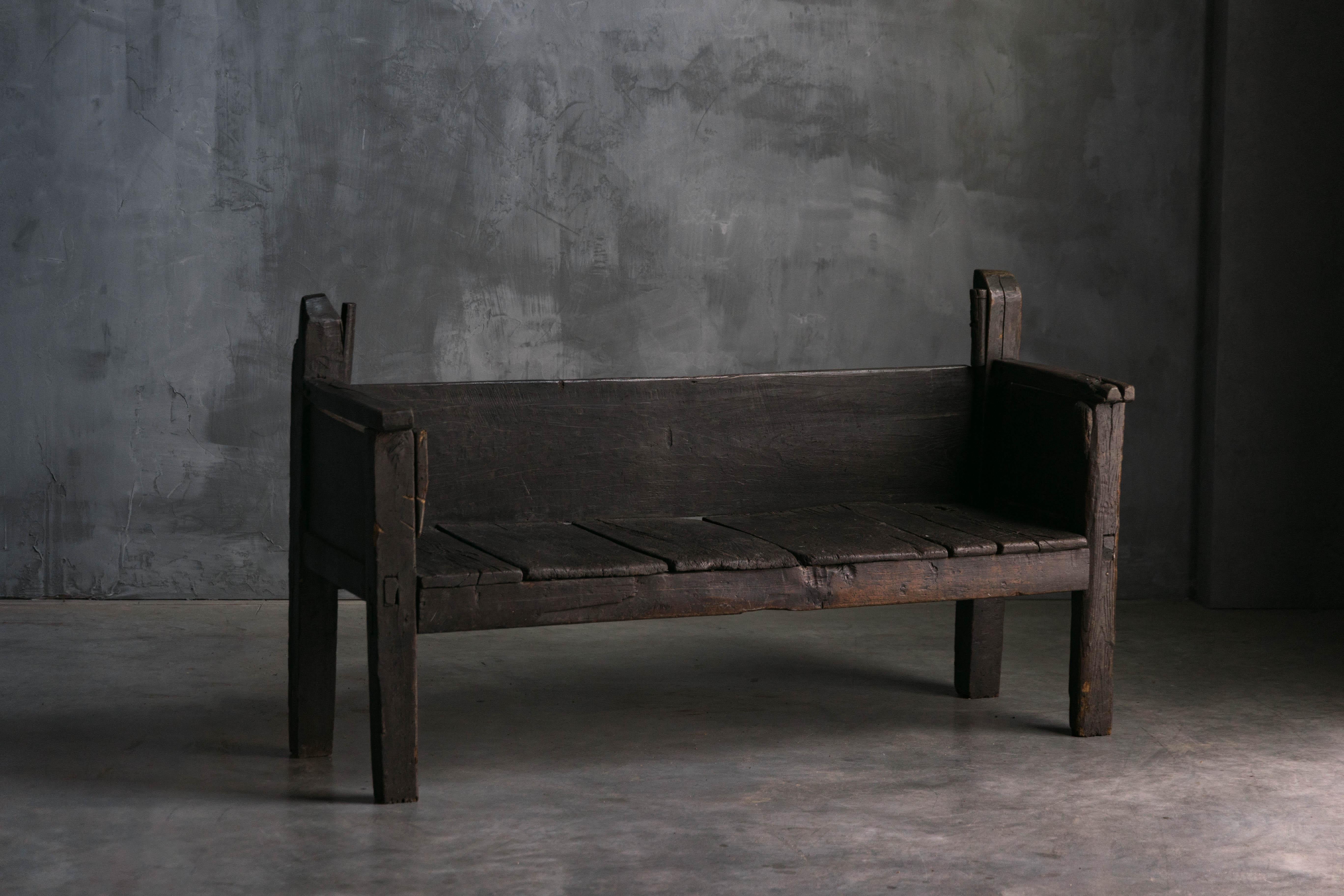 Banc rustique d'art populaire français du XIXe siècle, présentant un charmant caractère primitif. Construit en bois foncé robuste, le banc arbore une riche patine qui témoigne de son âge et de son histoire. Les imperfections naturelles et l'usure