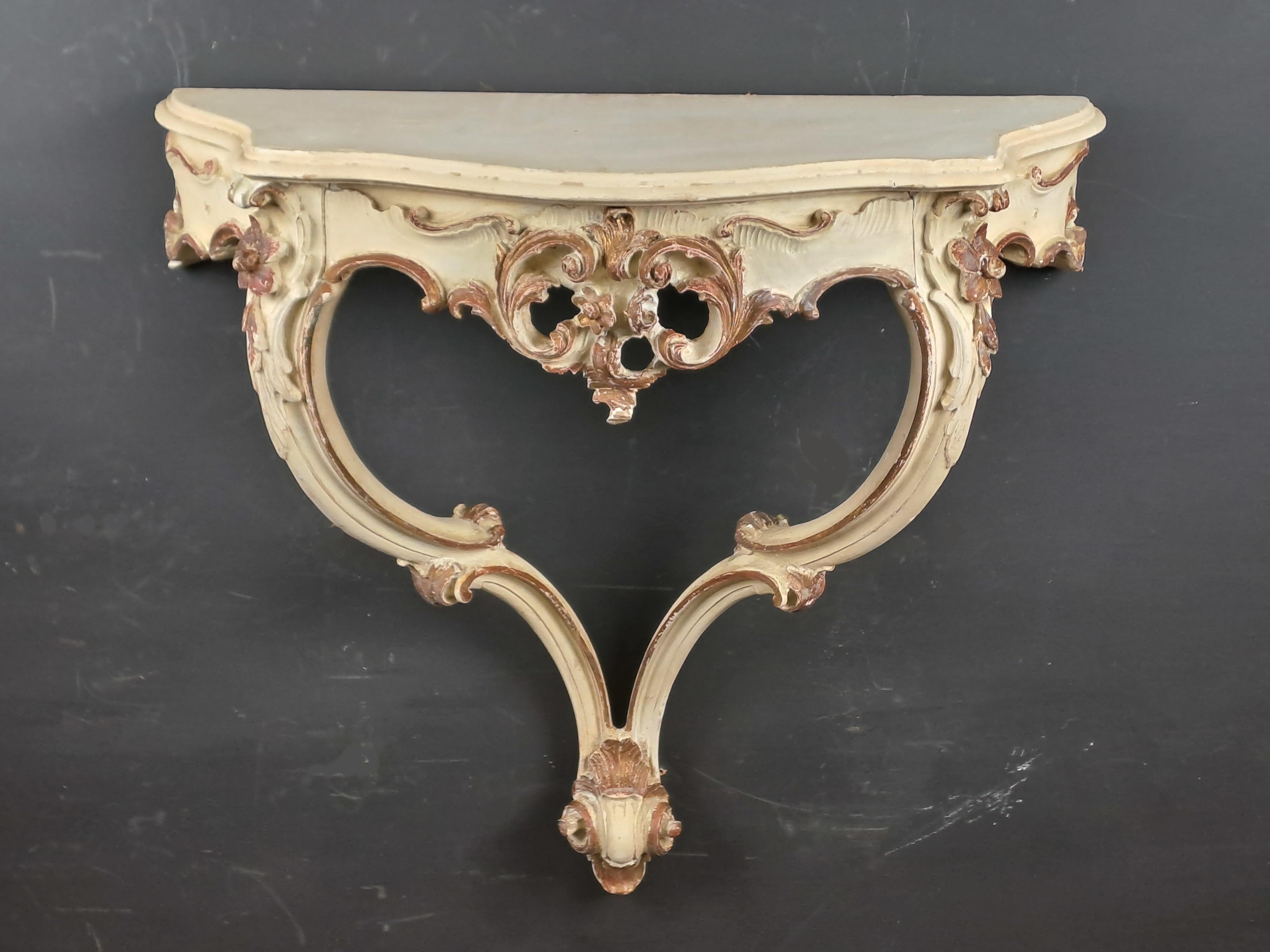 Charming little Louis XV Rocaille style wall console in cream lacquered wood and gold accents.
Generous carved decoration of acanthus leaves, flowers and foliage.
Opening a drawer.

French or Italian work around 1950.

Perfect proportions and
