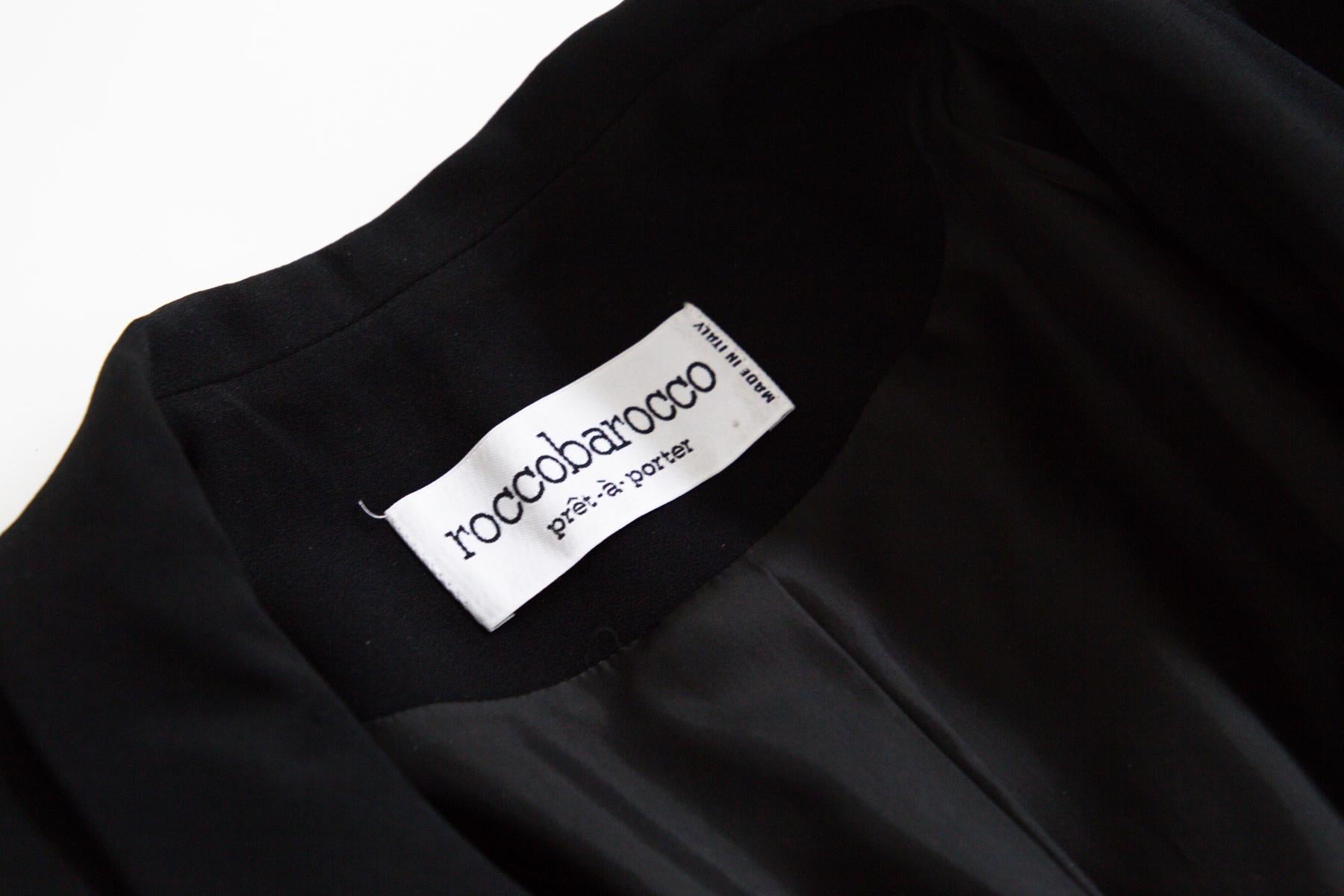 Beautiful elegant blazer from the 1990s by Rocco Barocco, made in Italy.
ORIGINAL LABEL.
The blazer is totally black and has long sleeves with soft cuffs adorned with one important button each. The collar has a classic standard wide cut. There are 4