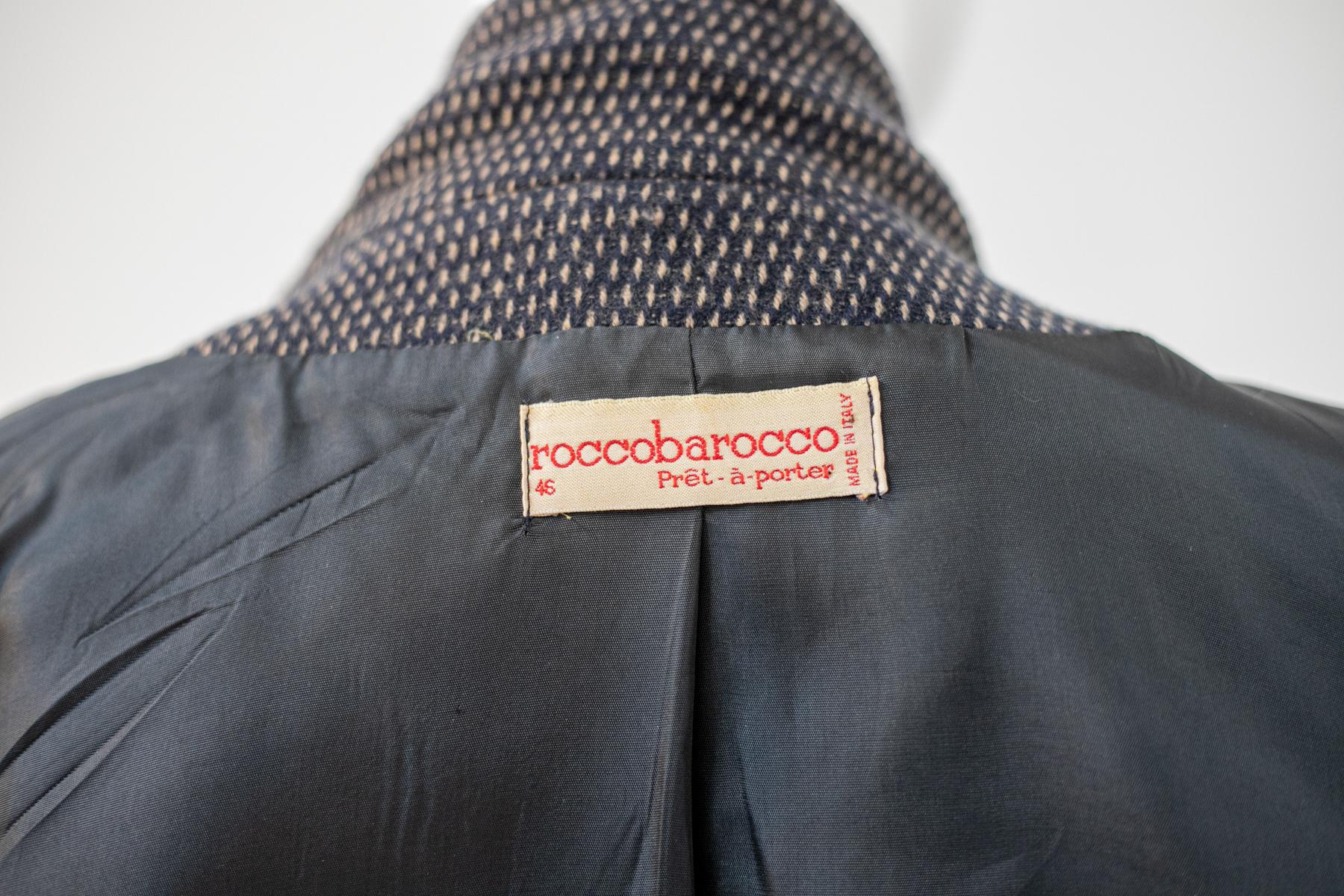 Beautiful elegant wool blazer from the 1990s by Rocco Barocco, made in Italy.
ORIGINAL LABEL.
The blazer is totally black wool and has long sleeves with soft cuffs adorned with one black button each. The collar has a classic standard wide and deep
