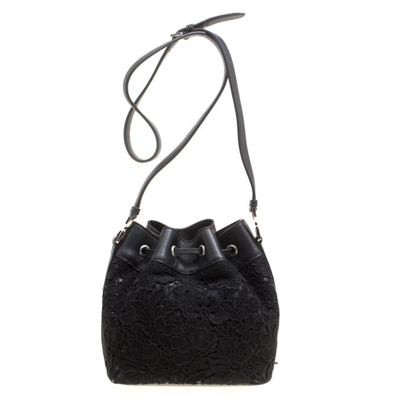 This stunning Rochas design has a lace exterior with leather trims. The bag has a bucket shape with a drawstring closure that secures the leather interior. It is complete with a shoulder strap.

Includes: Original Dustbag, Original Box

