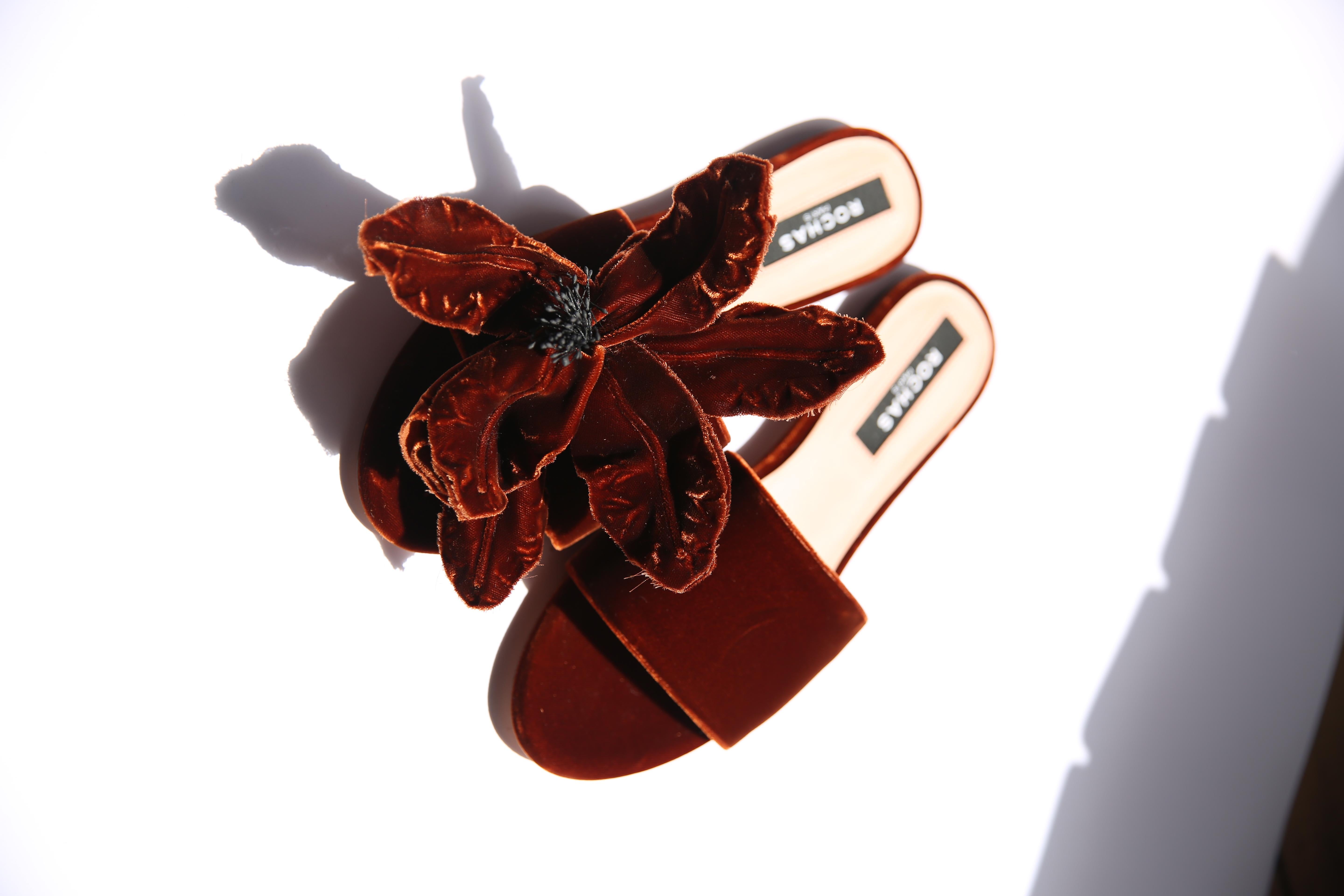 Rochas velvet slides with a large oversized floral appliqué 
Colour is a dark burnt orange/sepia
Made in Italy
These are brand new though the left shoe seems to have a slight indent to the velvet (Please refer to the photographs)
Come without their