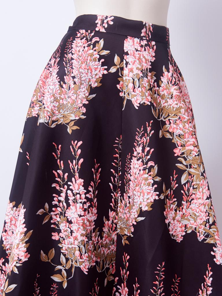 Olivier Theyskens, for Rochas, floral pattern, silk, evening skirt, having a flat banded waist, and deep, gathered, flounce starting at the knee and going down to the floor. Lovely shades of pink on a black ground. Back zipper closure.