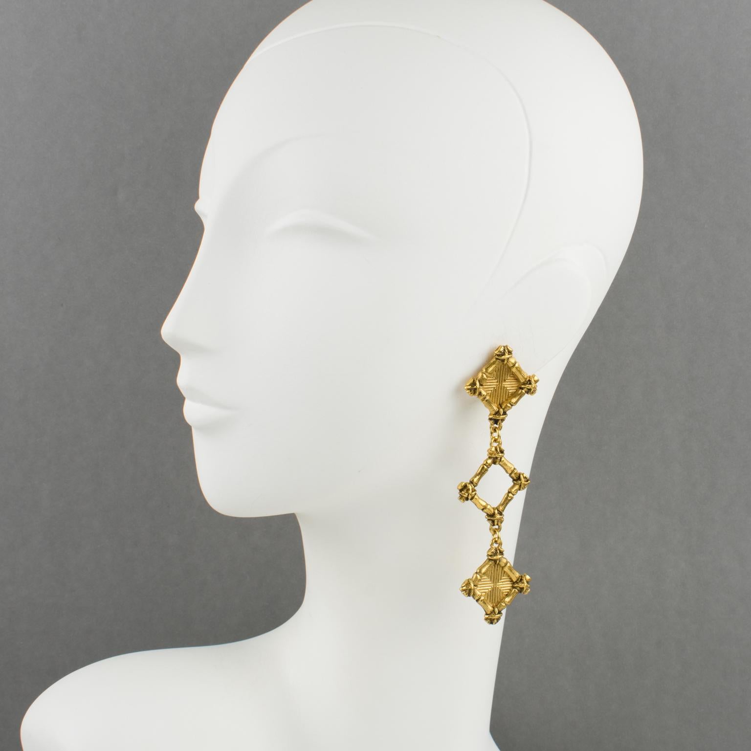 Lovely Rochas Paris dangling clip-on earrings. Long drop design, with carved and textured gilt metal geometric elements. Signed at the back with engraved logo: 