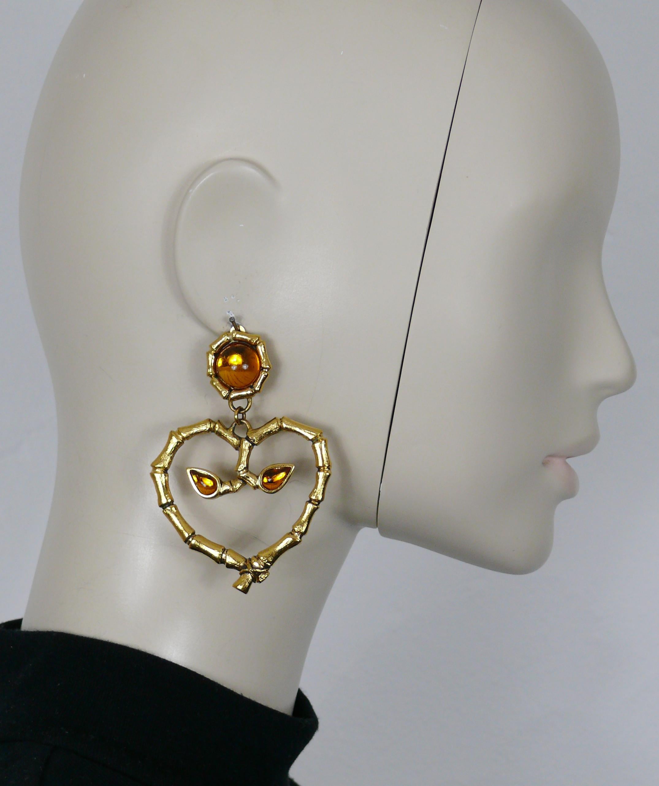 ROCHAS vintage antiqued gold tone heart shaped dangling earrings (clip-on) featuring a bamboo design with orange glass cabochons embellishement.

Embossed ROCHAS PARIS Made in France.

Indicative measurements : max. height approx. 7.7 cm (3.03