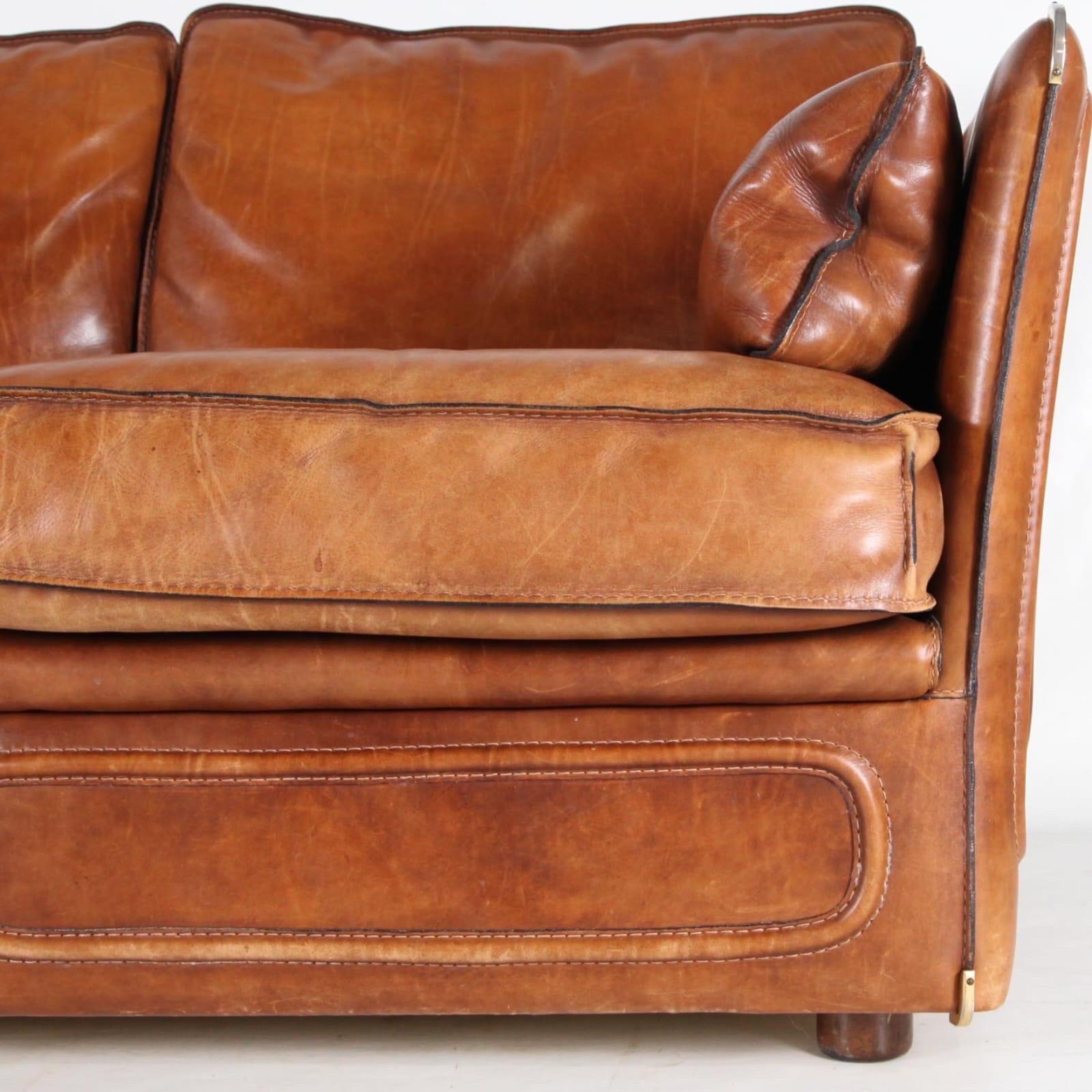 Roche Bobois 3 seaters leather sofa from the seventies. Thick buffalo leather, wooden legs, brass corners, very good quality. 
Comfortable, very good condition and wonderful patina.
Loveseat (2 seaters) available too on this site. 