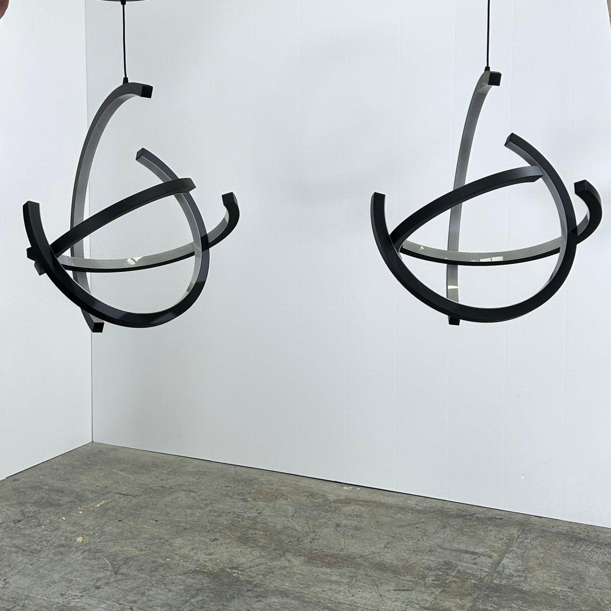Introducing the Roche Bobois Atom Suspension Light, a stunning creation by renowned designer Cédric Ragot. This set of two suspension lights features a unique and modern design, with a sleek and minimalist aesthetic. The Atom Suspension Light is
