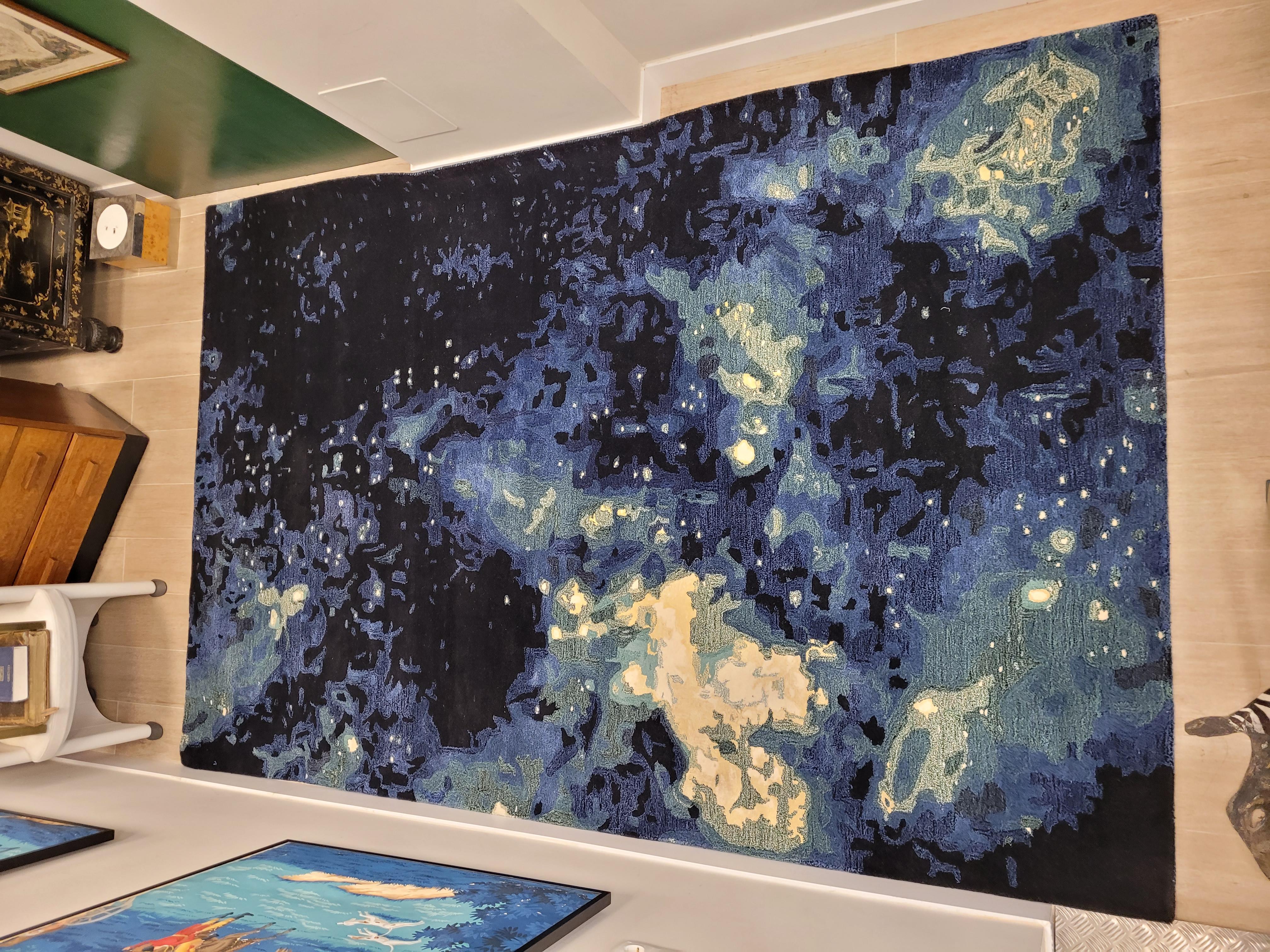 Amazing and gorgeous  “Galaxy” model rug in bleu nuit, handmade for Roche Robois. Large in size, this piece is a trip to outer space thanks to the infinite luminous constellations that are represented in it. Created with different shades of blue, it