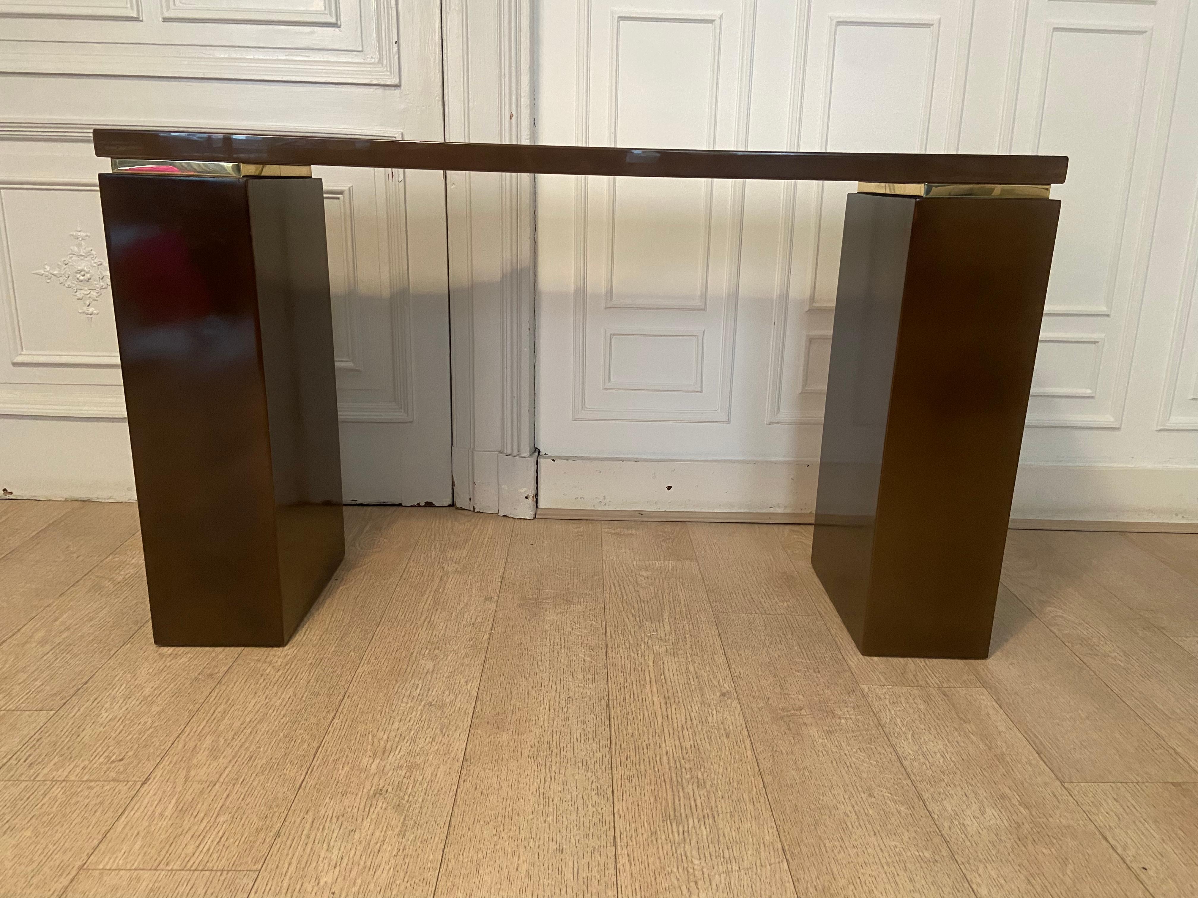 Roche bobois console produced in the 70s. Brown lacquer with moiré effects and gold ornaments.
 