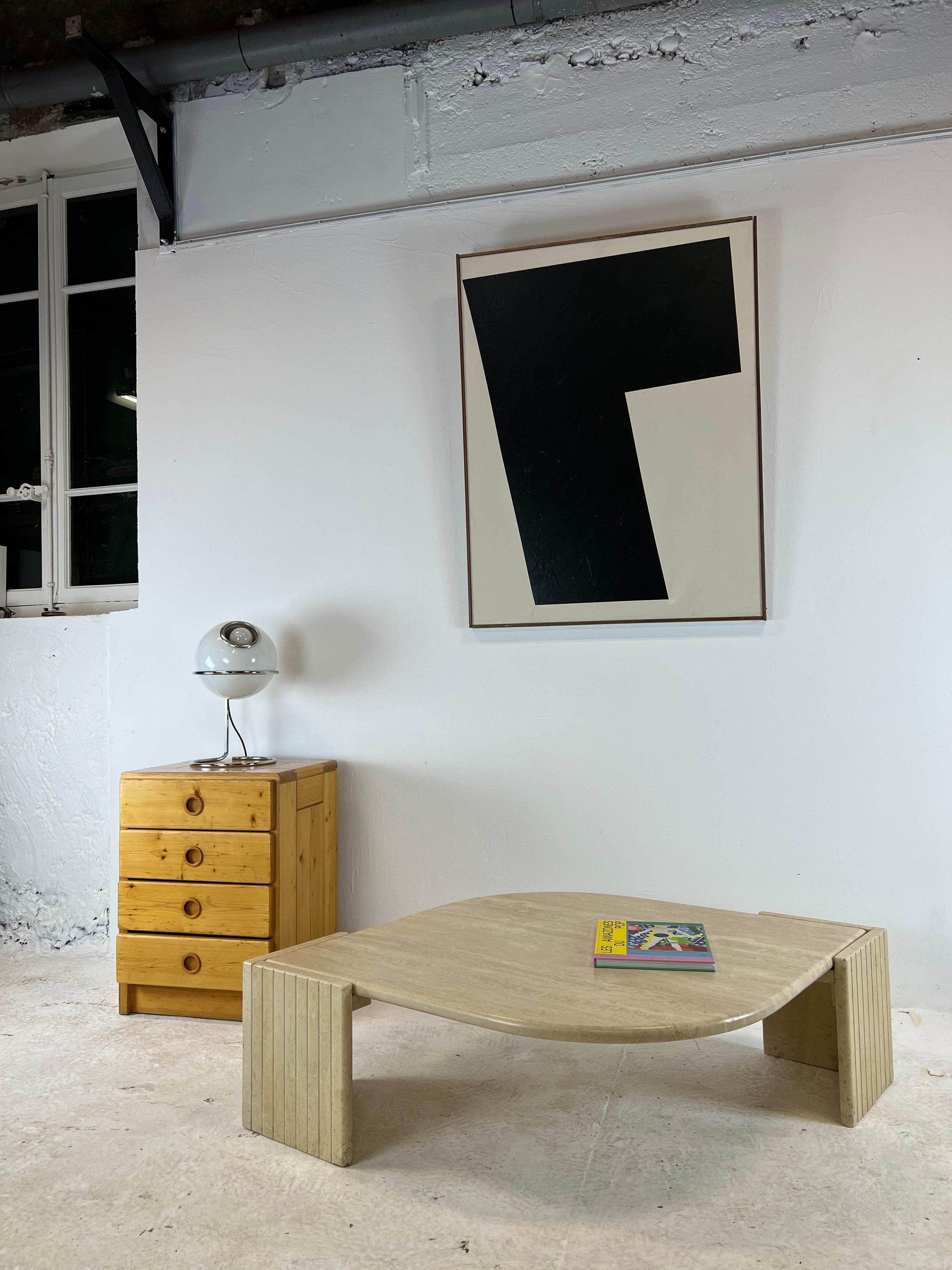 Iconic coffee table in the shape of an eye produced by roche bobois in the 70s. In travertine, its base accommodates the teardrop top which is housed there. Heavy and robust, its design is particularly attractive and it will fit perfectly into a