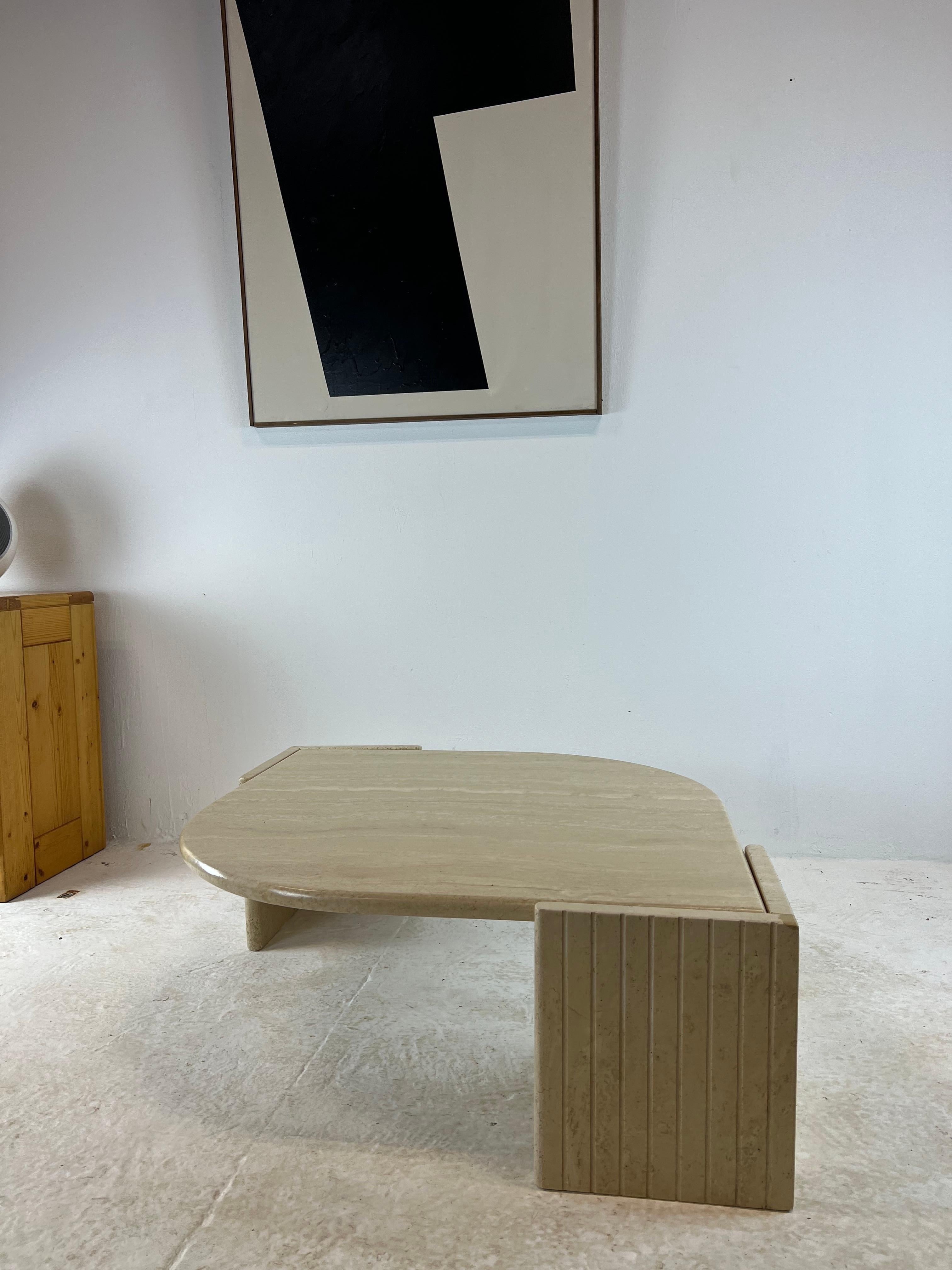 Iconic coffee table in the shape of an eye produced by roche bobois in the 70s. In travertine, its base accommodates the teardrop top which is housed there. Heavy and robust, its design is particularly attractive and it will fit perfectly into a