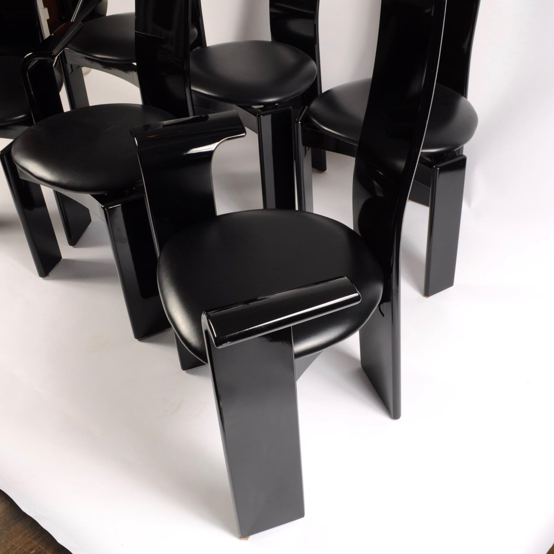 Set aus 6 sauberen italienischen Stühlen aus schwarzem Lack mit hoher Rückenlehne:: abgerundeten Wasserfallarmen und Sitzkissen aus schwarzem Leder. Gekauft bei Roche Bobois in den 1970er Jahren. Jede Rückseite ist mit einer Grafik im Memphis-Stil