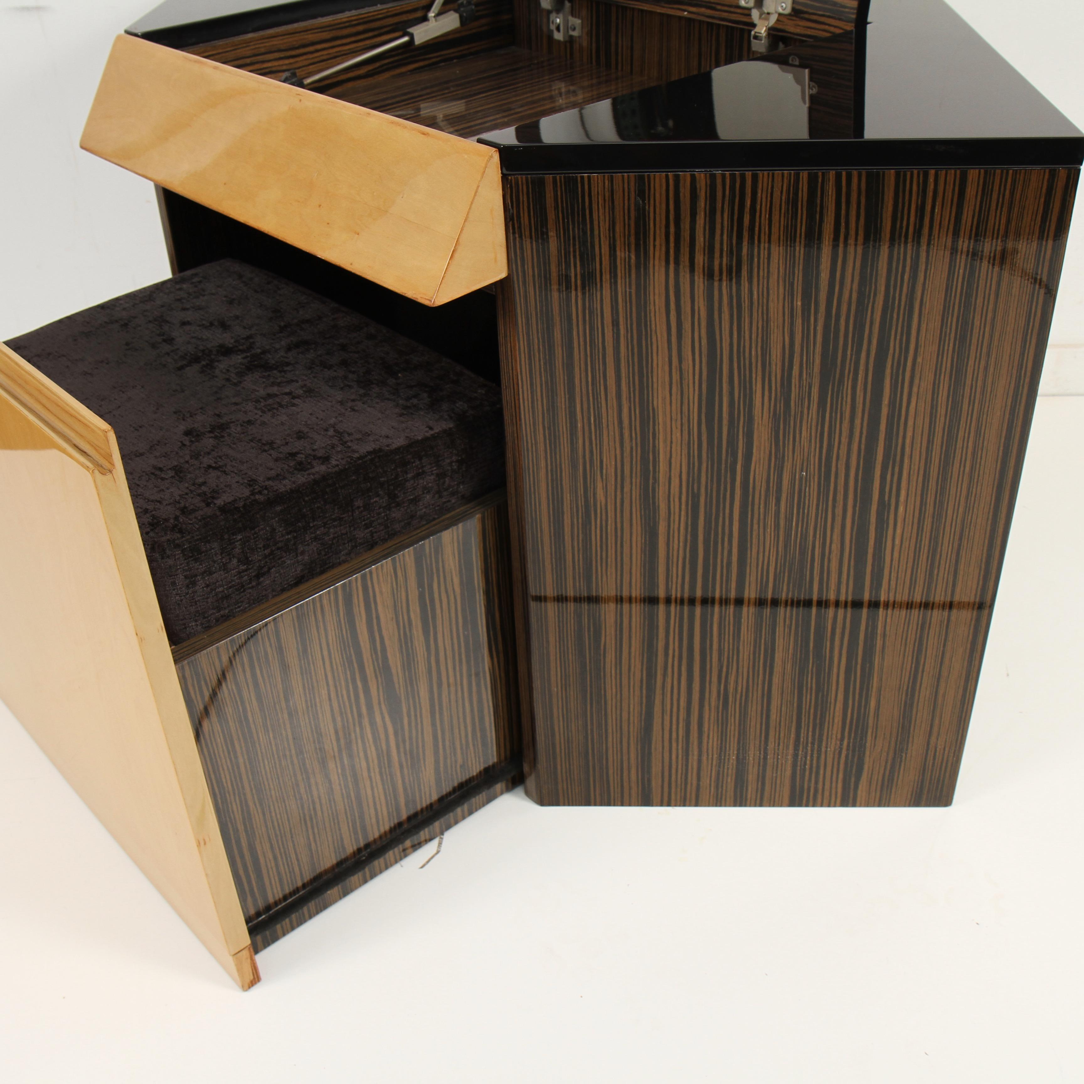 Really clever and well-designed corner vanity with integrated matching seat that slides into vanity's base. A nice mix of ebony, Makassar and birch veneers.
