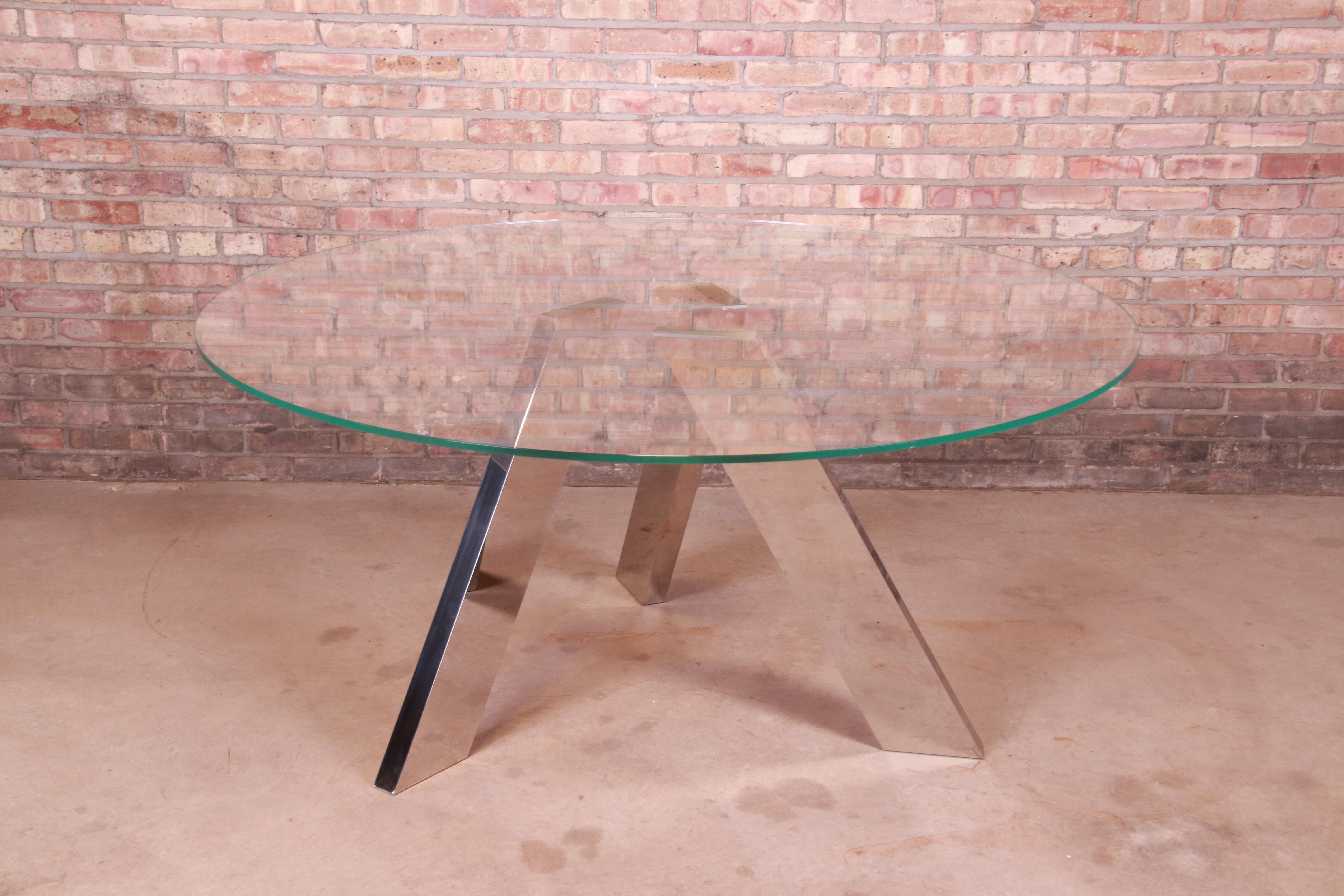 A stunning modern sculptural dining or center table

By Roche Bobois

Circa 1980s

Architectural mirrored chrome pedestal legs, with thick glass top.

Measures: 62