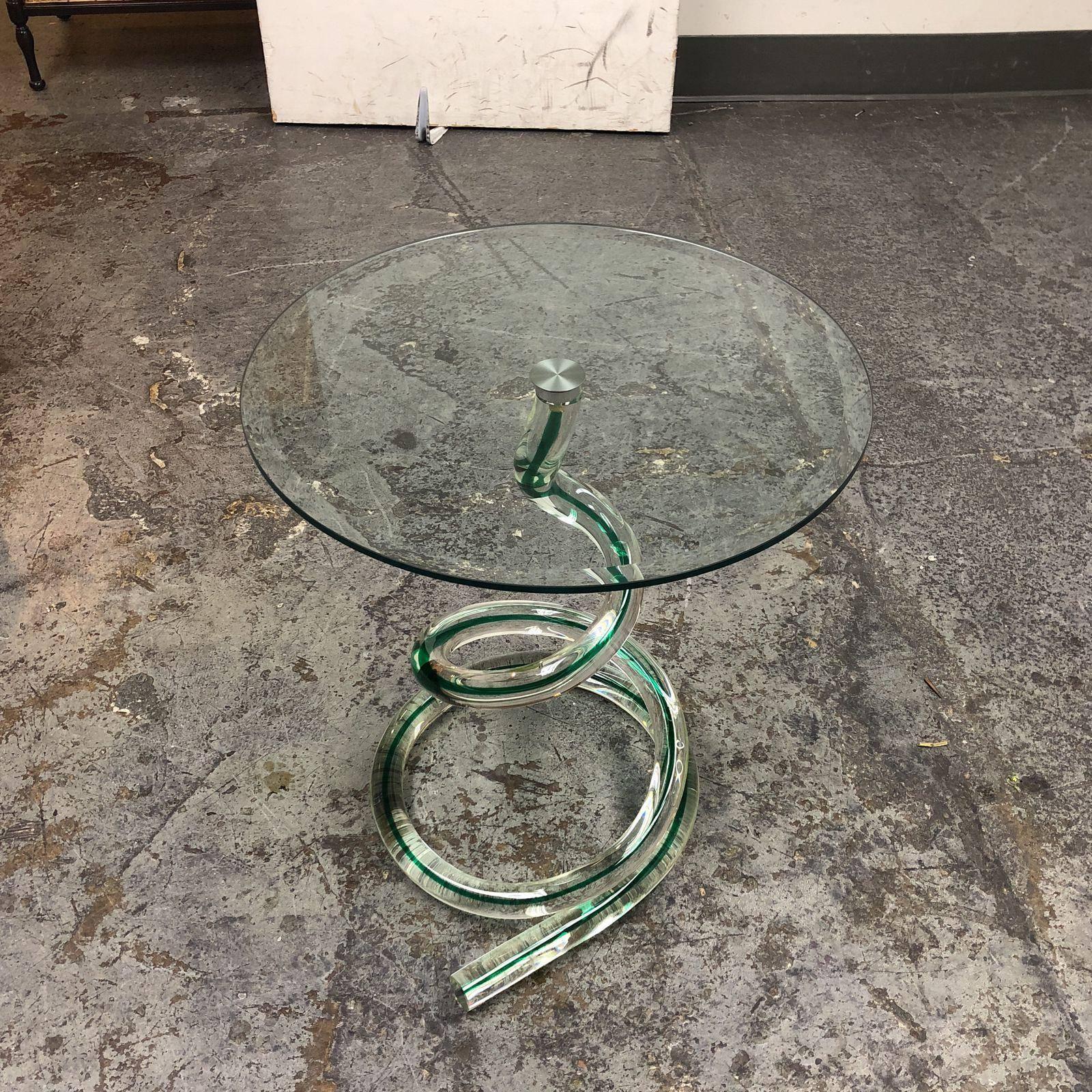 A Murano glass Ghibli side table from Roche Bobois. A brilliant green vein swirls through the solid glass coil that is the base of the table, topped with a bevelled round glass.
 
 