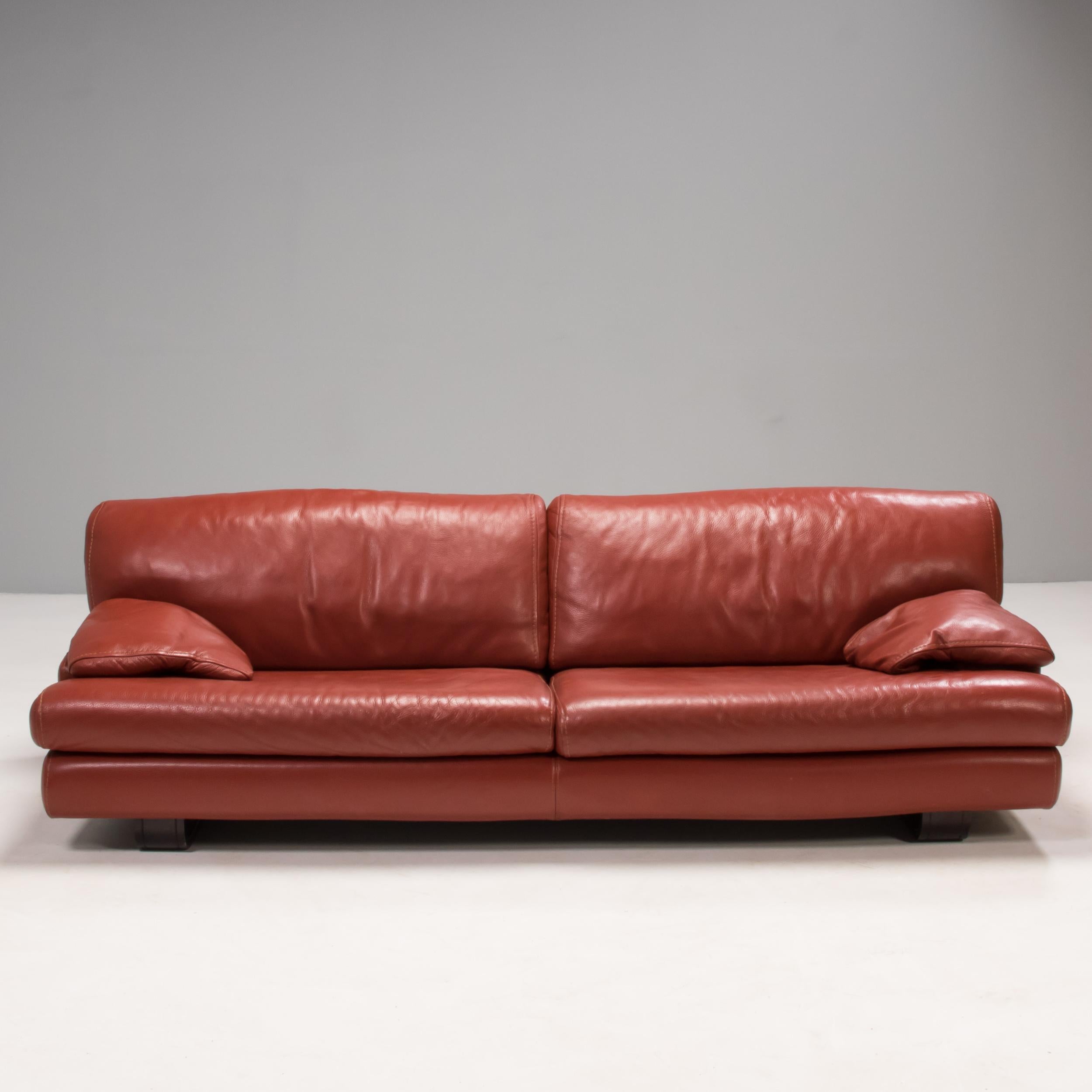 Designed by Roche Bobois, this sofa offers the ultimate in comfort with deep seating and soft red leather upholstery.

The sofa features two seat cushions and two back cushions with additional cushions which become the armrests, as well as a