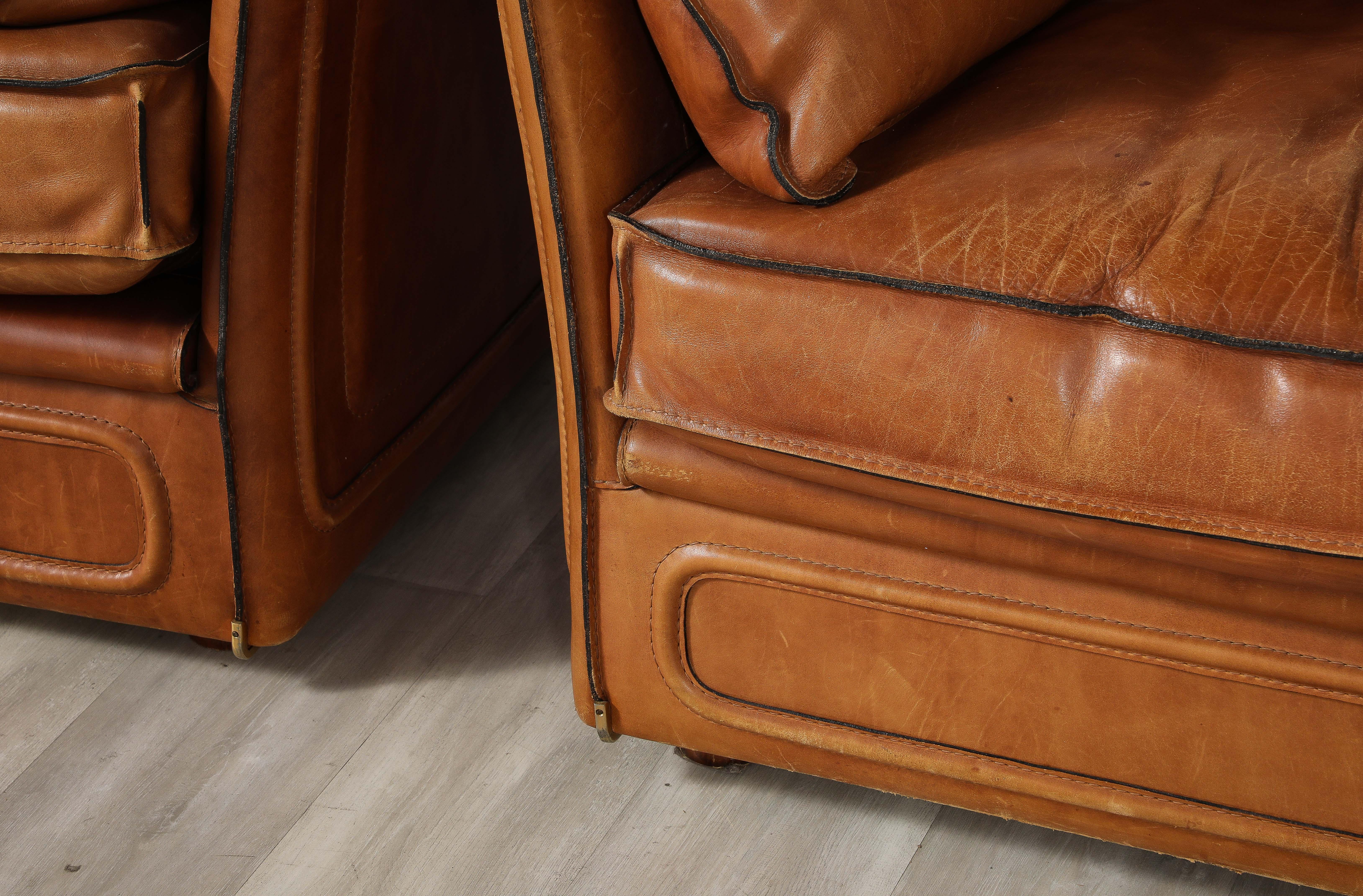 A pair of Roche Bobois saddle leather chairs, circa, late 1970's.  The pair are incredibly stylish French chairs in the manner of Hermes, with wonderful proportions and are covered in sumptuous thick saddle leather with stitched edges and chrome