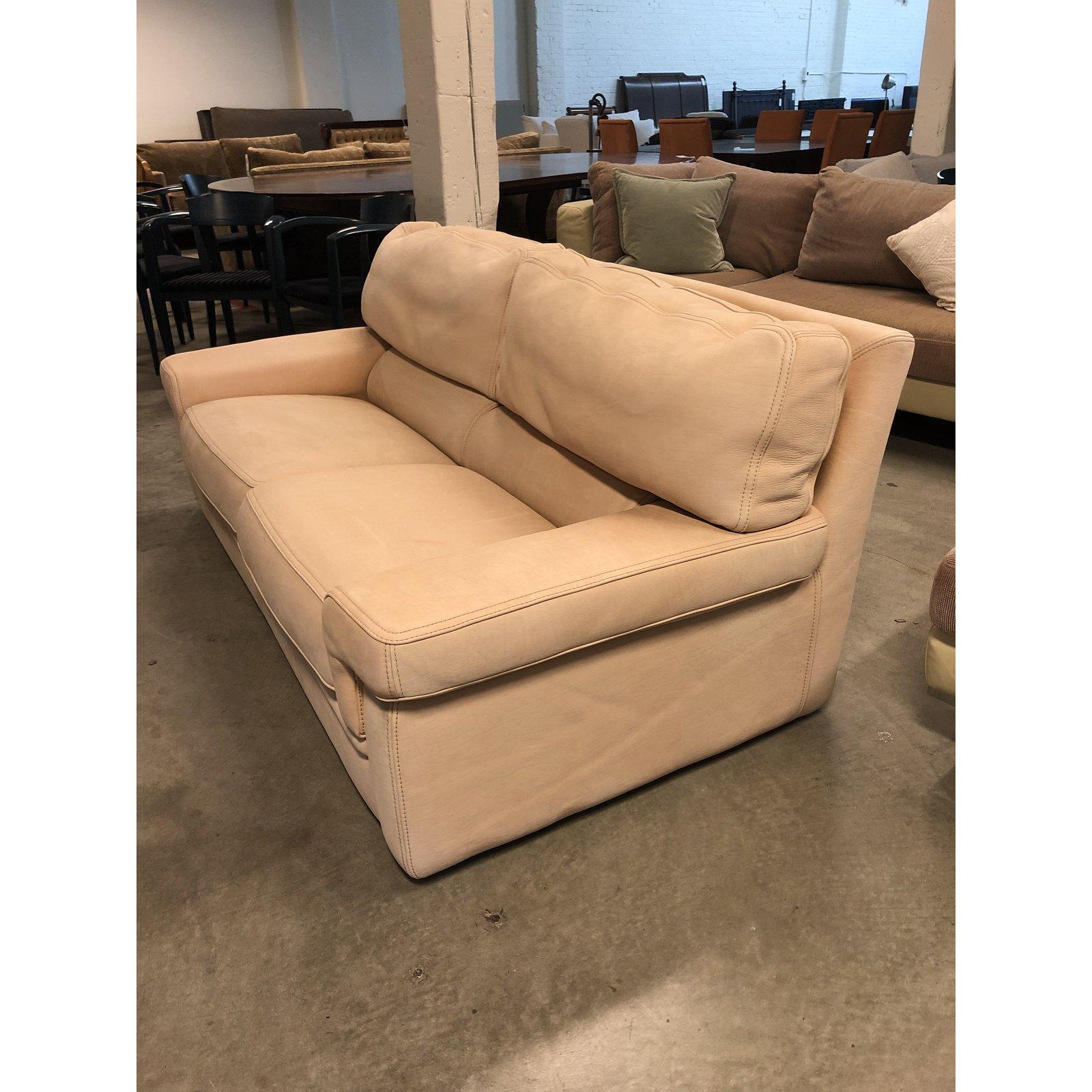 A leather loveseat by Roche Bobois. This lovely seating is from the Particuliere collection of Roche Bobois. A clean design upholstered in leather, visible fading on leather. The back cushions zip off. The piece was reupholstered, original branding