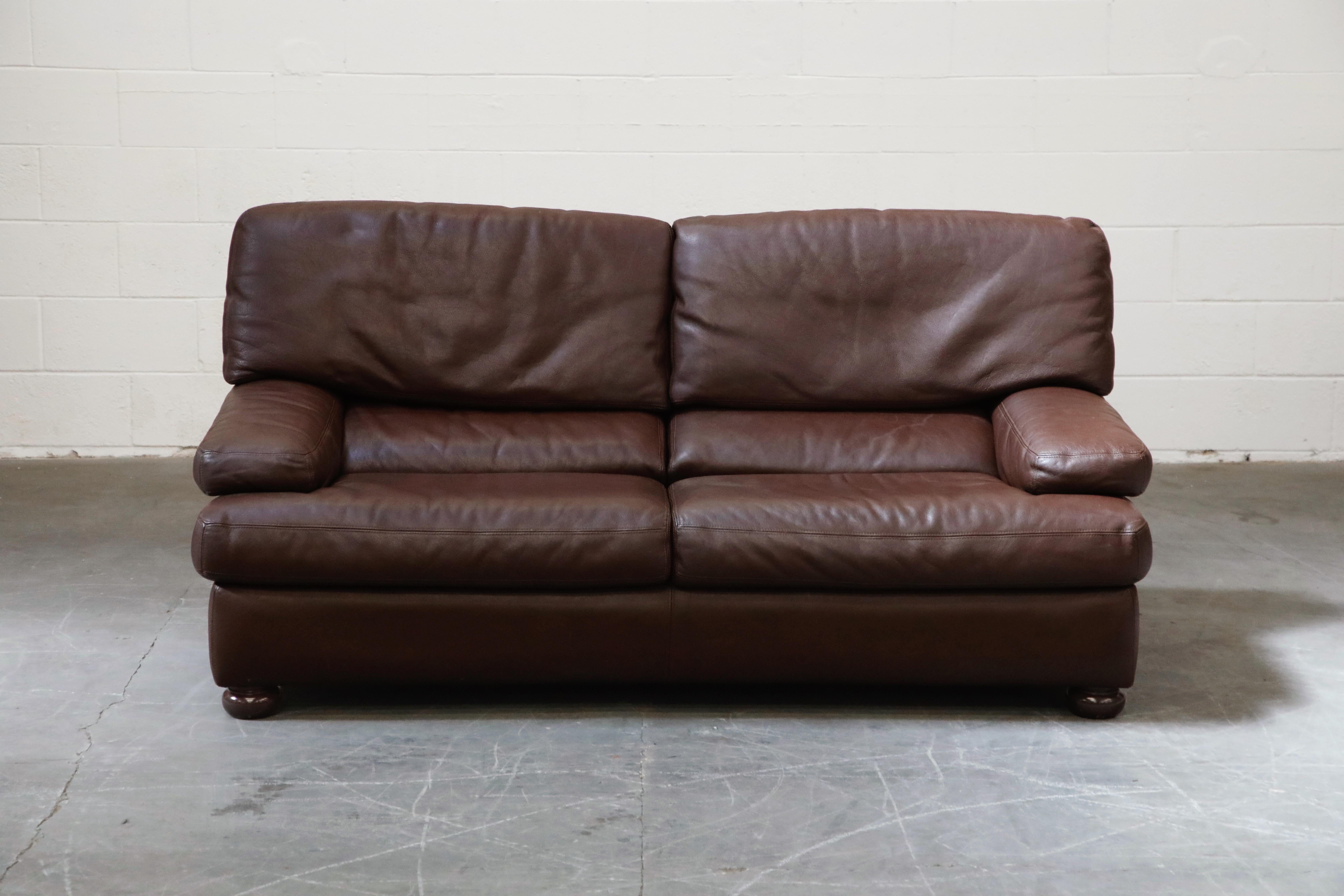 Soft comfortable leather and incredible Post-Modern style in this living room set by Roche Bobois, Paris France, circa 1980s, consisting of a one loveseat and two club chairs. The deep brown colored leather is the high quality you would expect from