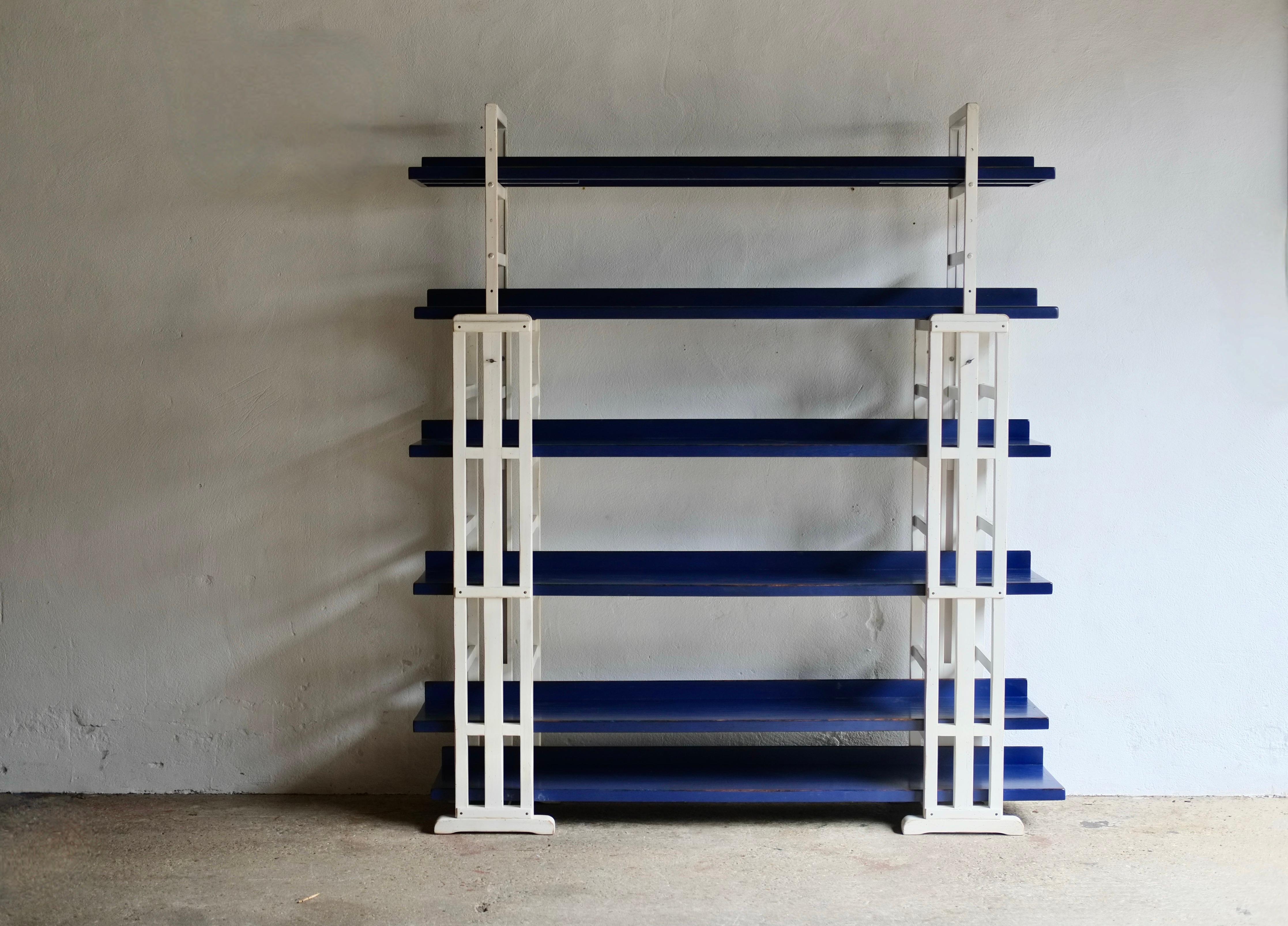 A large wooden shelving unit by French company Roche Bobois. White painted height adjustable frames and blue painted shelves, the unit is reminiscent of the designs of the De Stijl movement from the early 20th century. 

In good solid vintage