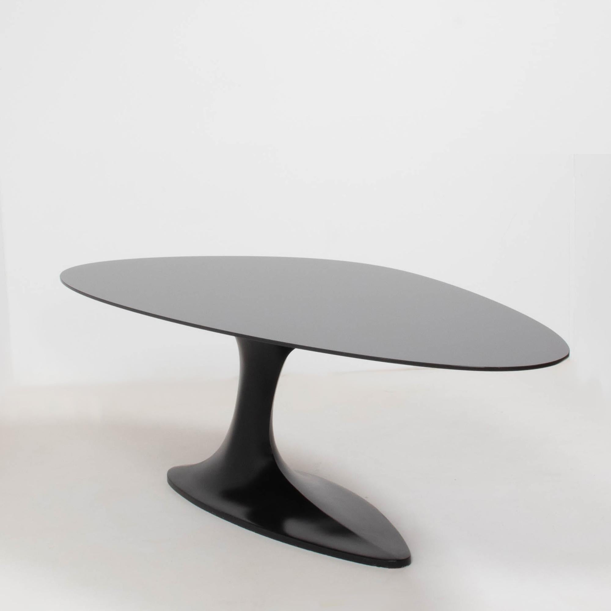 Designed by Sacha Lakic for Roche Bobois, the ‘Speed Up’ collection was a limited edition series inspired by movement, asymmetry and speed.

The dining table features an elliptical black glass top, sitting on a single black fibre-resin pedestal