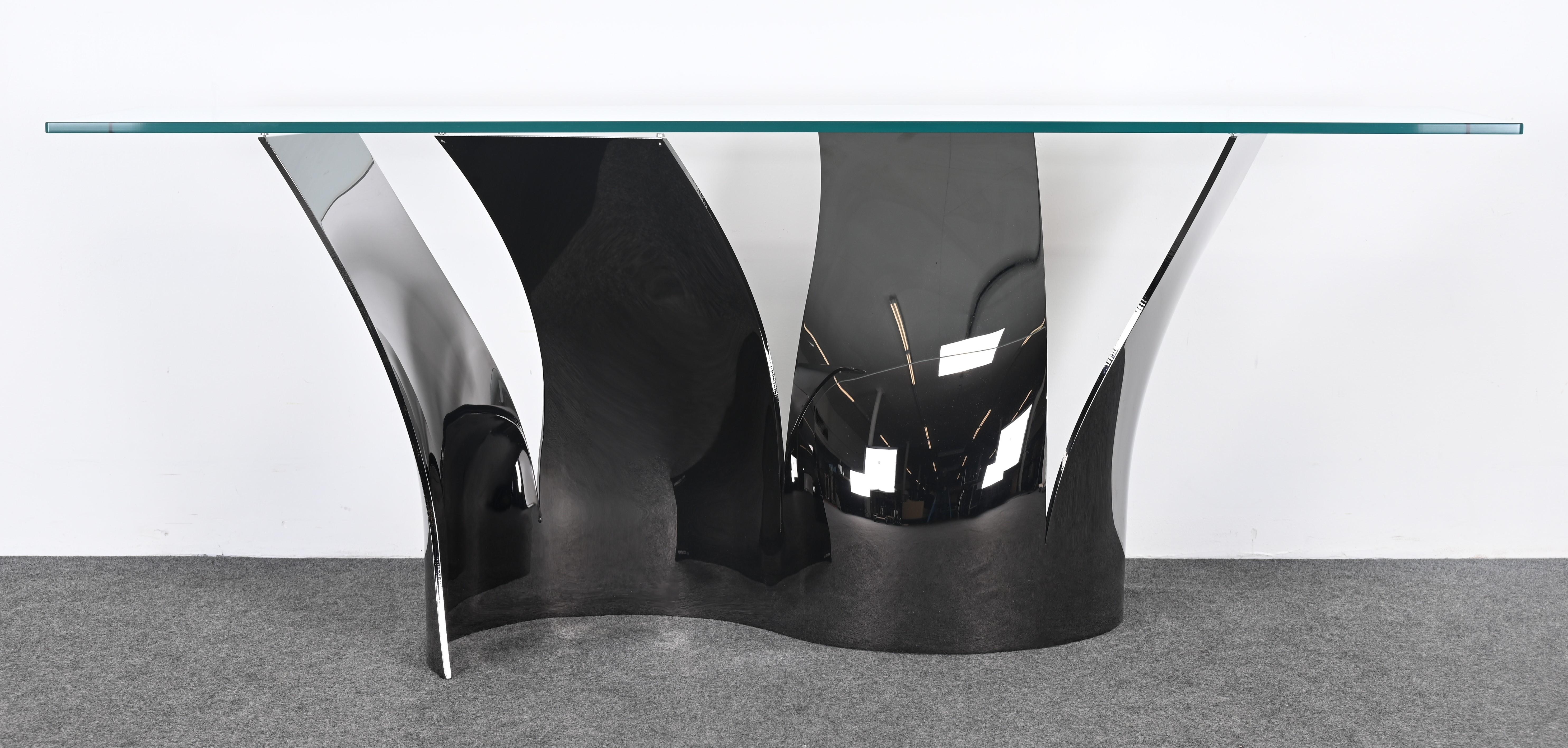 A modern formed steel console table with a black nickel finish and glass top 
called 