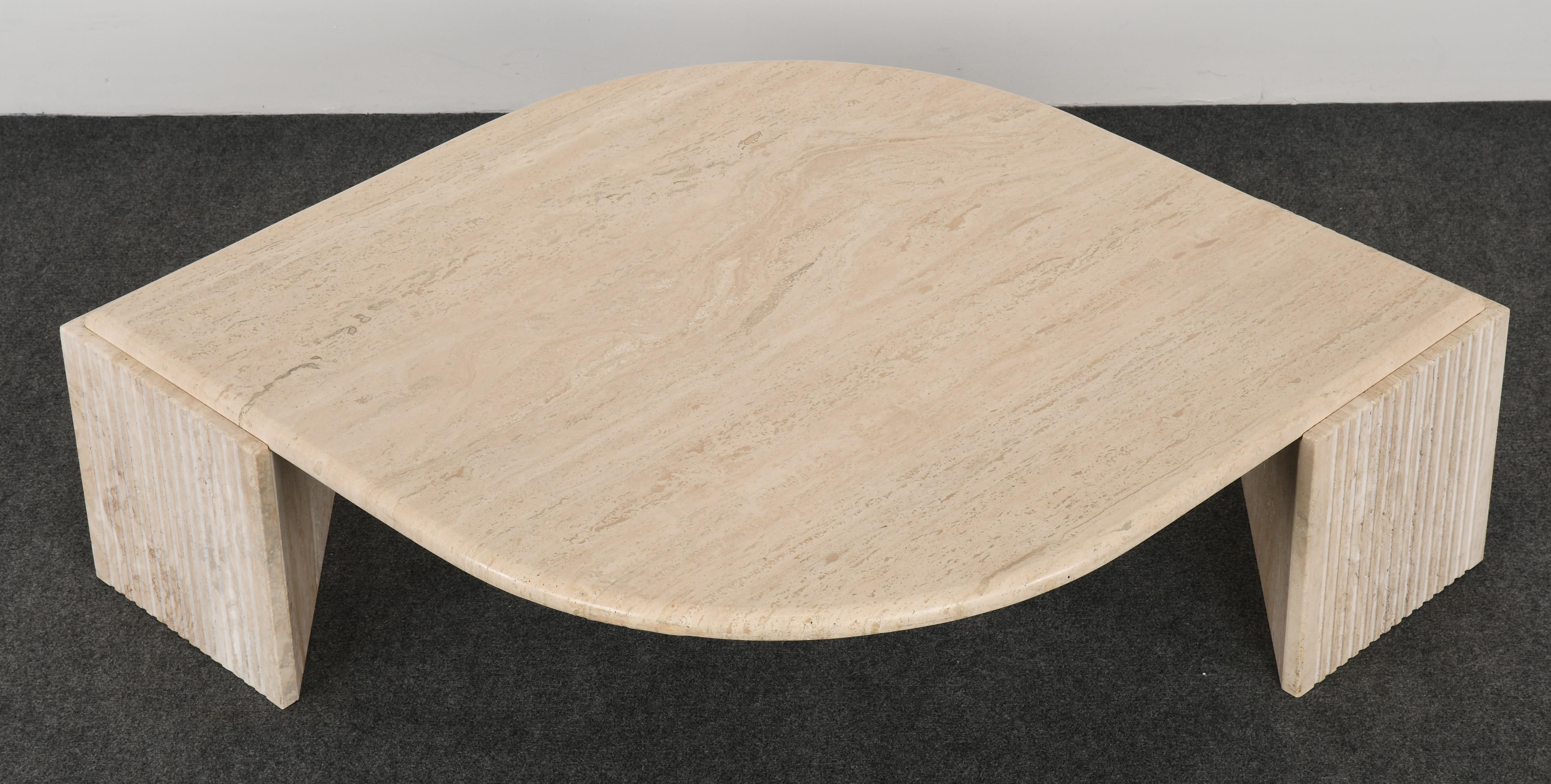 A beautiful Roche Bobois style travertine cocktail or coffee table. This table has two fluted or ribbed bases with a teardrop top. The table is structurally sound with age-appropriate wear. One of two available.

Dimensions: 14.75