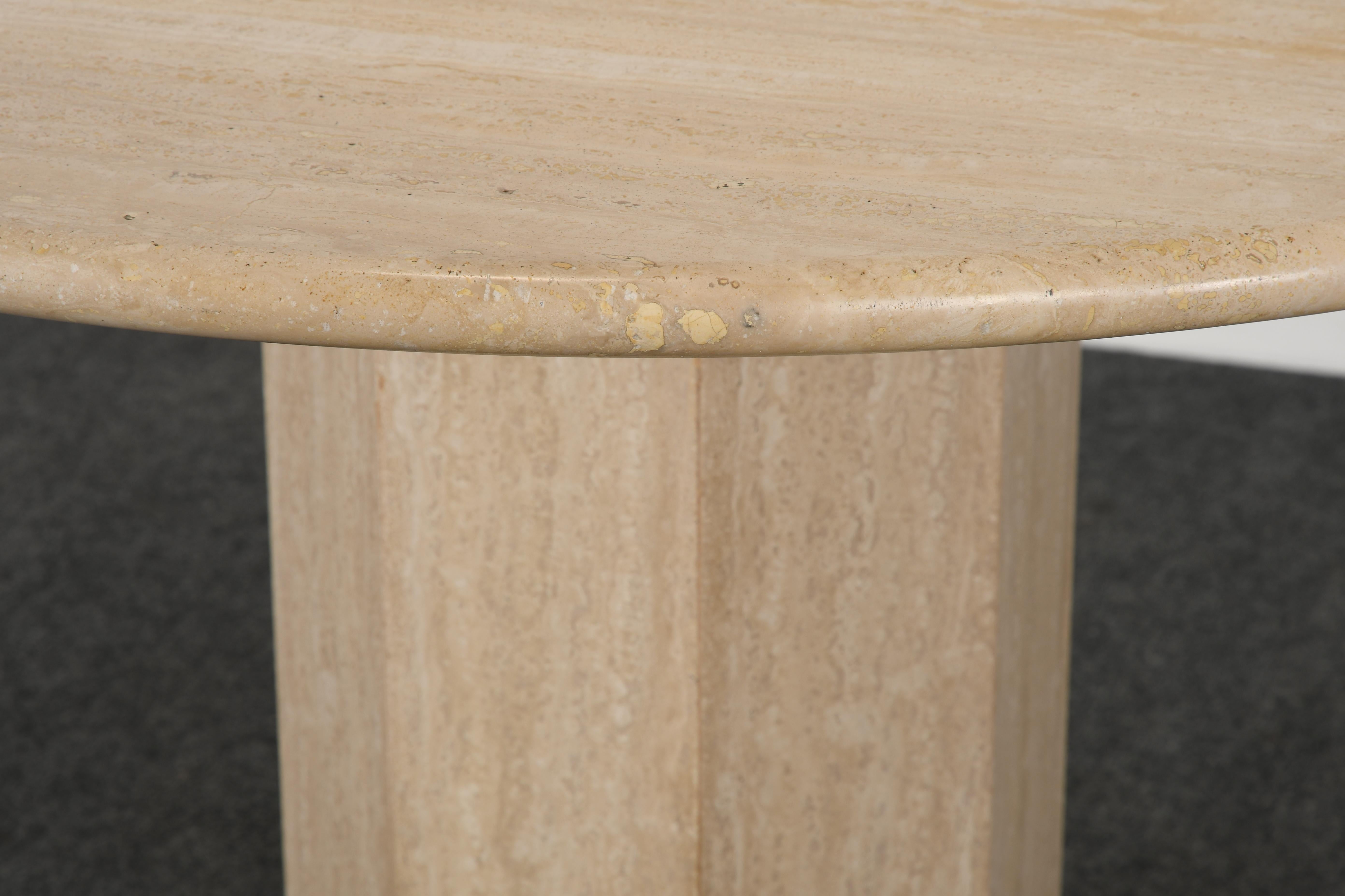 A modernist round travertine marble dining table with an octagonal base and bullnose edge. This is a beautiful example of stone with various variegated veins to surface.

The top has a low gloss finish and is etched in some areas throughout. This