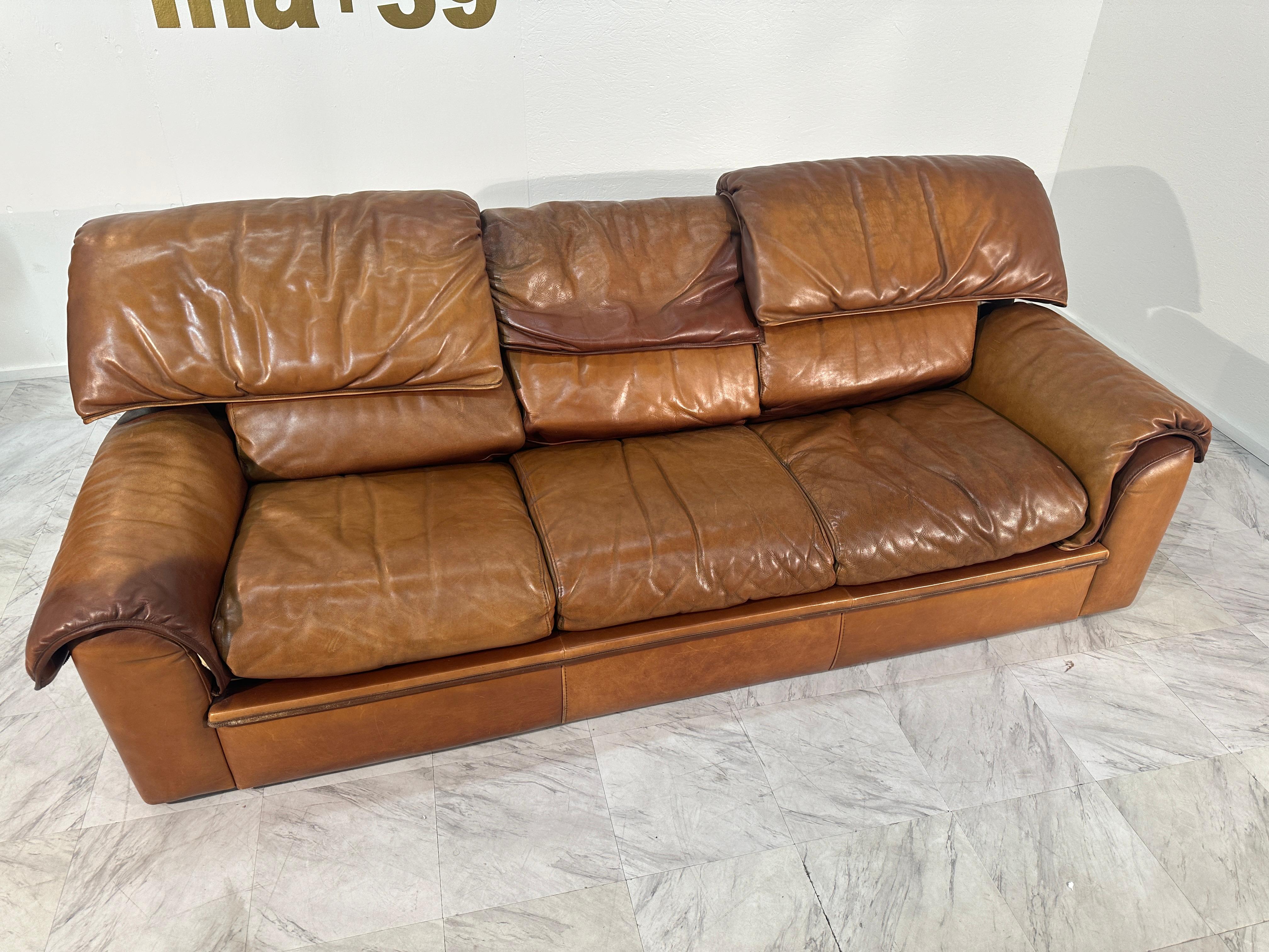 Il s'agit d'un canapé trois places de Roche Bobois, revêtu d'un riche cuir marron, qui dégage un charme vintage avec une touche d'élégance moderne. Le canapé est doté de coussins d'assise et de dossiers généreux et moelleux qui promettent un confort