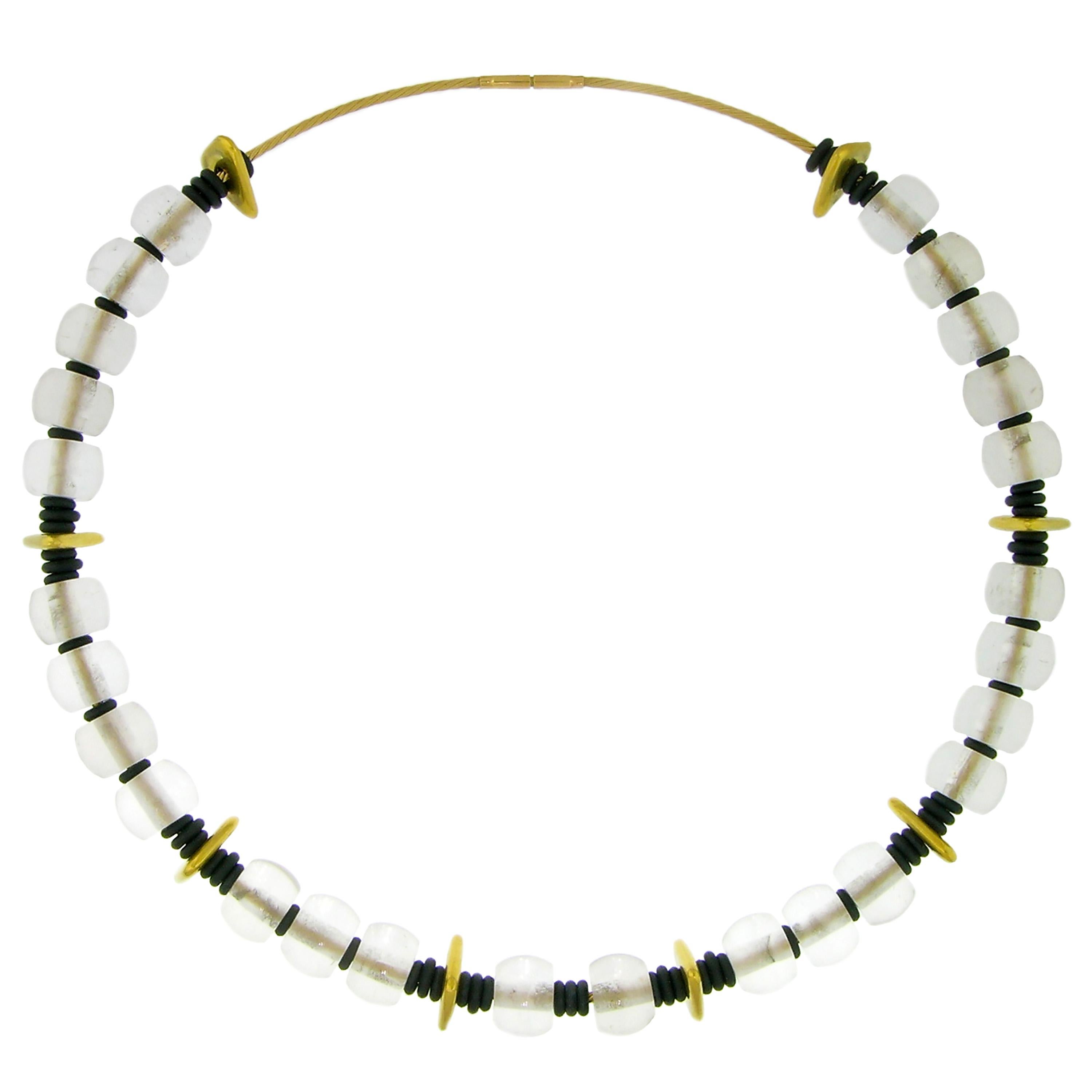 This gemstone beaded necklace features totally transparent, barrel shaped rock crystal beads accentuated by 20kt handmade gold triangles and unexpectedly delightful black neoprene spacers.

This whimsically conceived necklace allows for never-ending