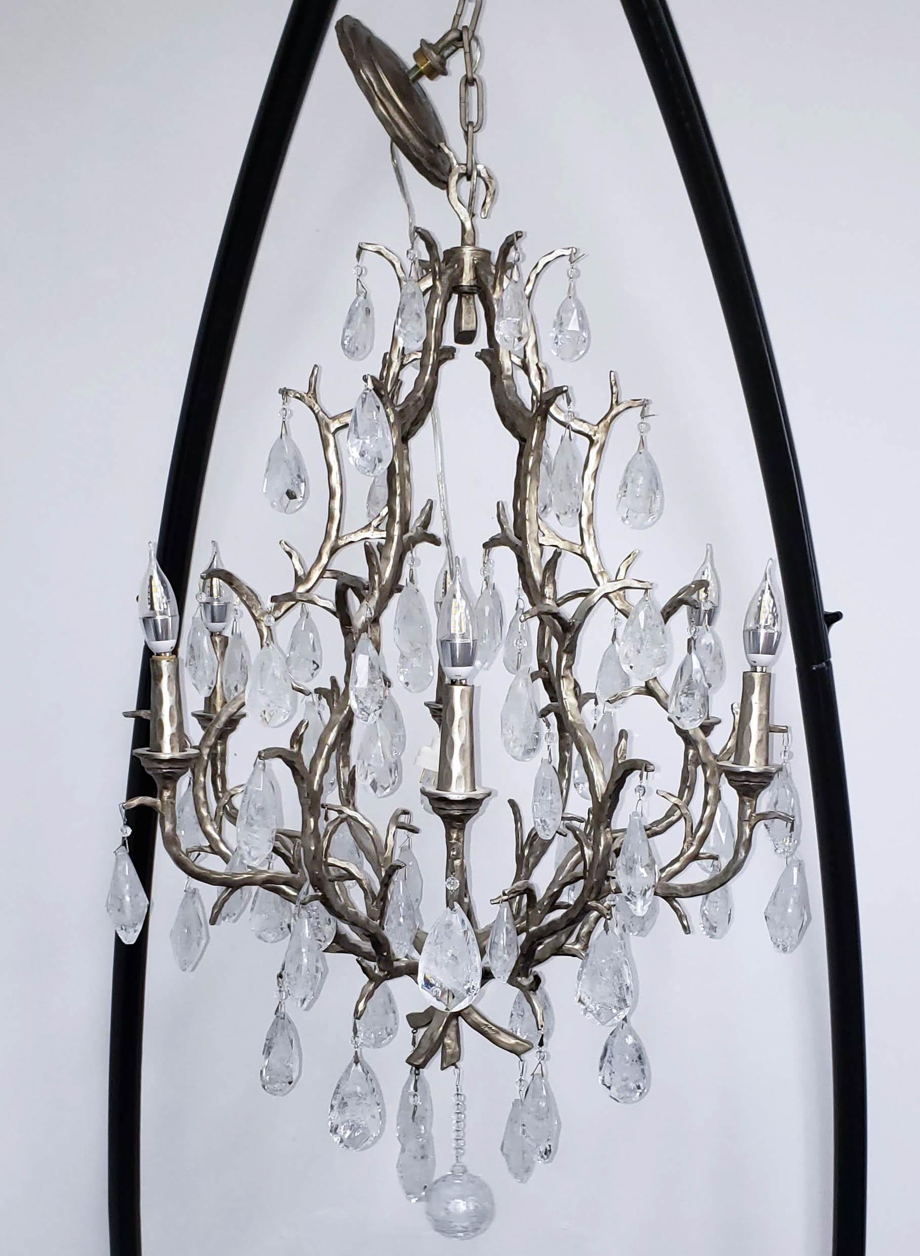 Hand-crafted iron rock crystal chandelier with six candlestick-style lights. This impressive work of functional art features rock crystal prisms that hang suspended from twig-like branches. 

COLOR: Muted silver. DIMENSIONS: 35 inches high x 25