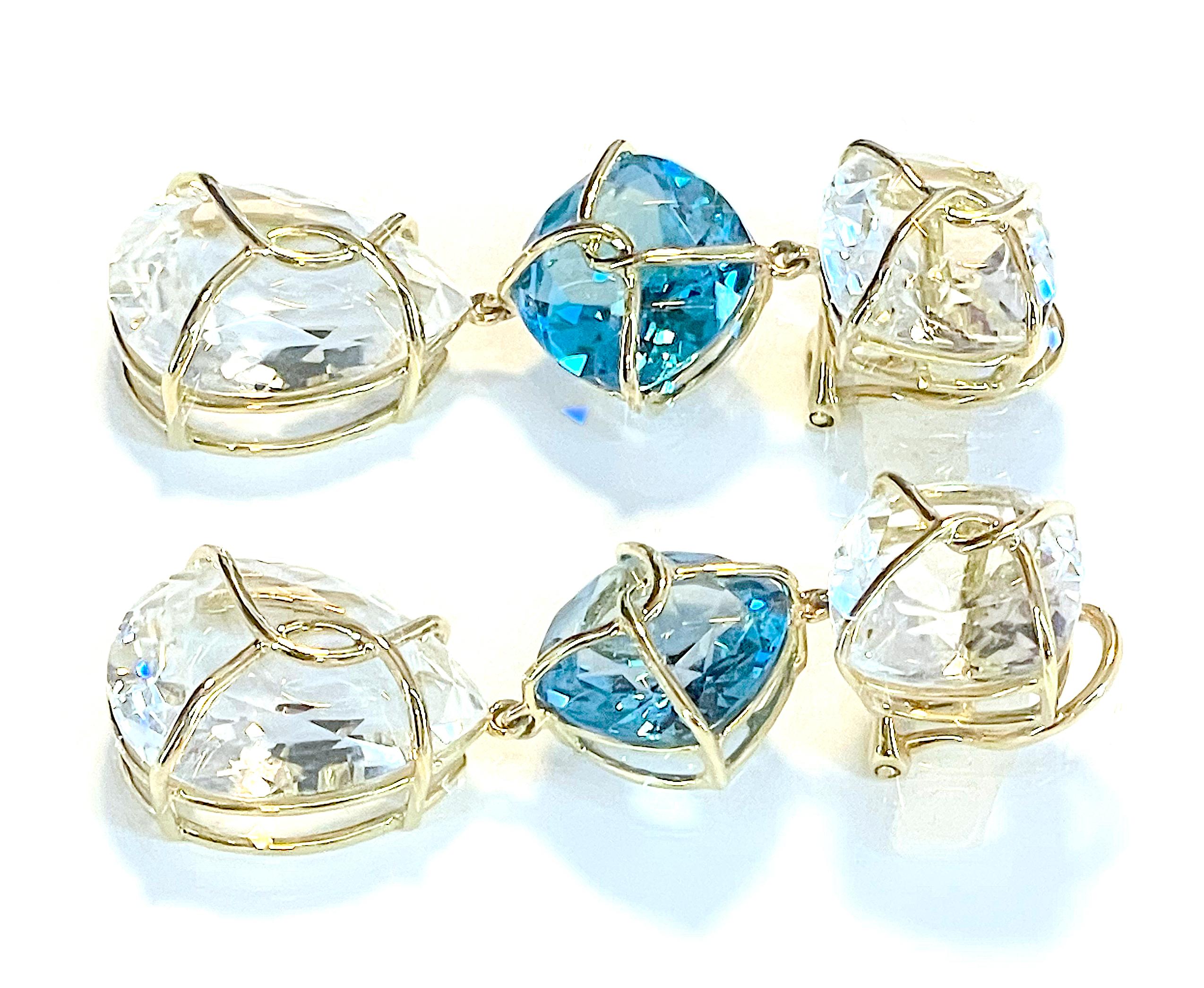 18kt Twisted Yellow Gold and Rock Crystal Drop Earring
 
This elegant earring measures two inches long. The top cushion is shaped Rock Crystal that measures half an inch wide. The middle cushion is shaped Blue Topaz also measures 1/2