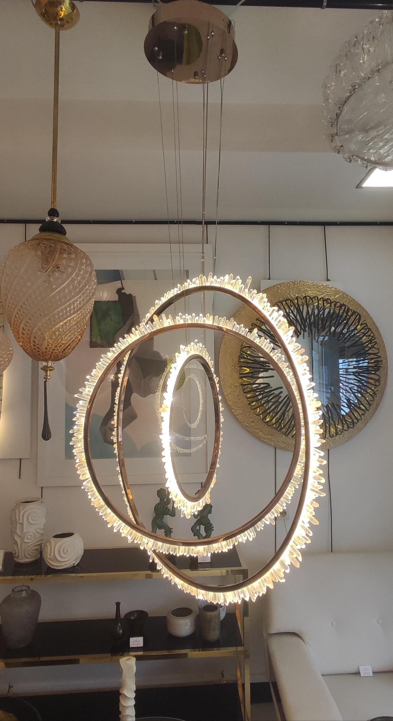 3 rock crystal ( natural stones) and brass circles ceiling light, illuminated by leds.
Measures: diameter 45 cm, diameter 65 cm, diameter 85 cm, 
Dimensions without crystals 40/60/80/
Adjustable height, here 160cm 
 but adjustable as far 2.2