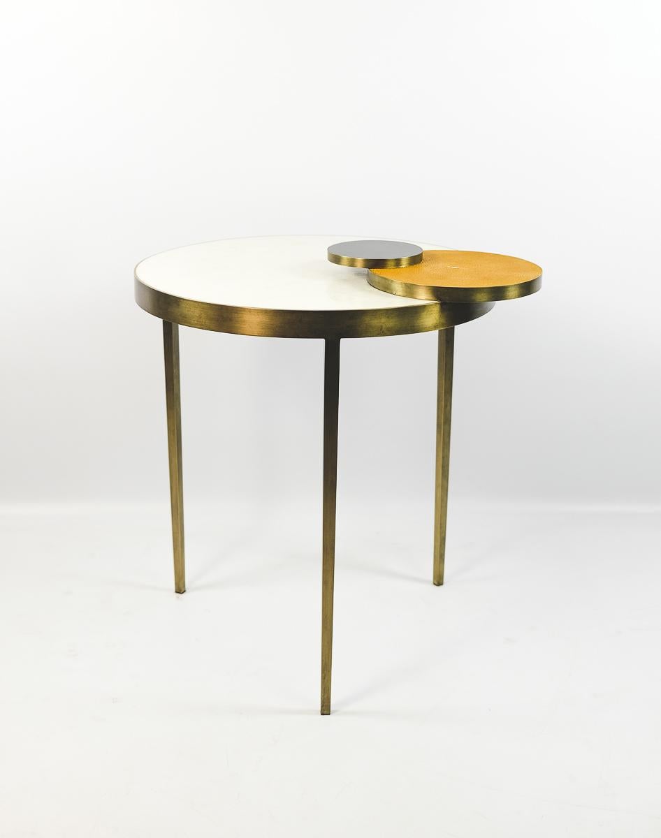 The nesting tables CIRCULO are made of a mix of natural materials.
It is mainly made with white rock crystal, with shagreen and polished black shell accents.
Each table has three legs and all the structure is made of brass with a bronzed