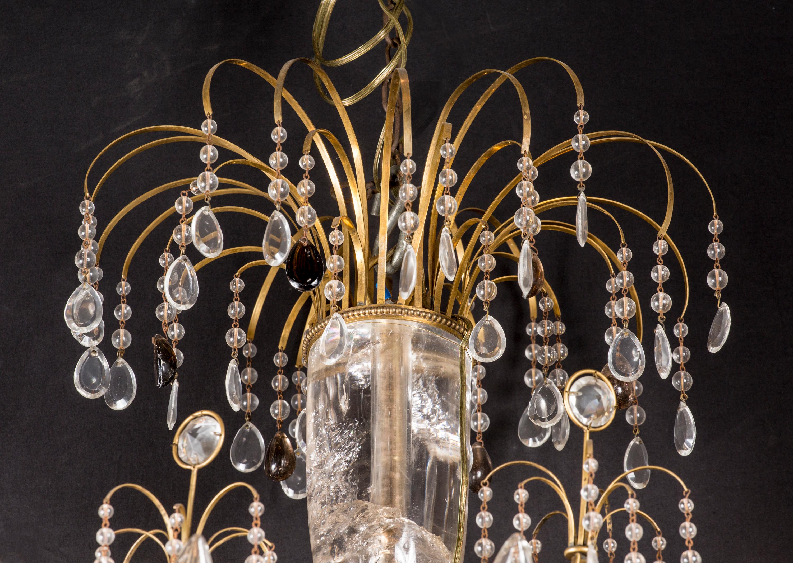 This exquisite Russian chandelier features incredibly fine rock crystal and a bronze d’ore frame. The rock crystal can be found most notably in the magnificent and massive center stem, as well as the spears on the upper tier. The shape of the piece,