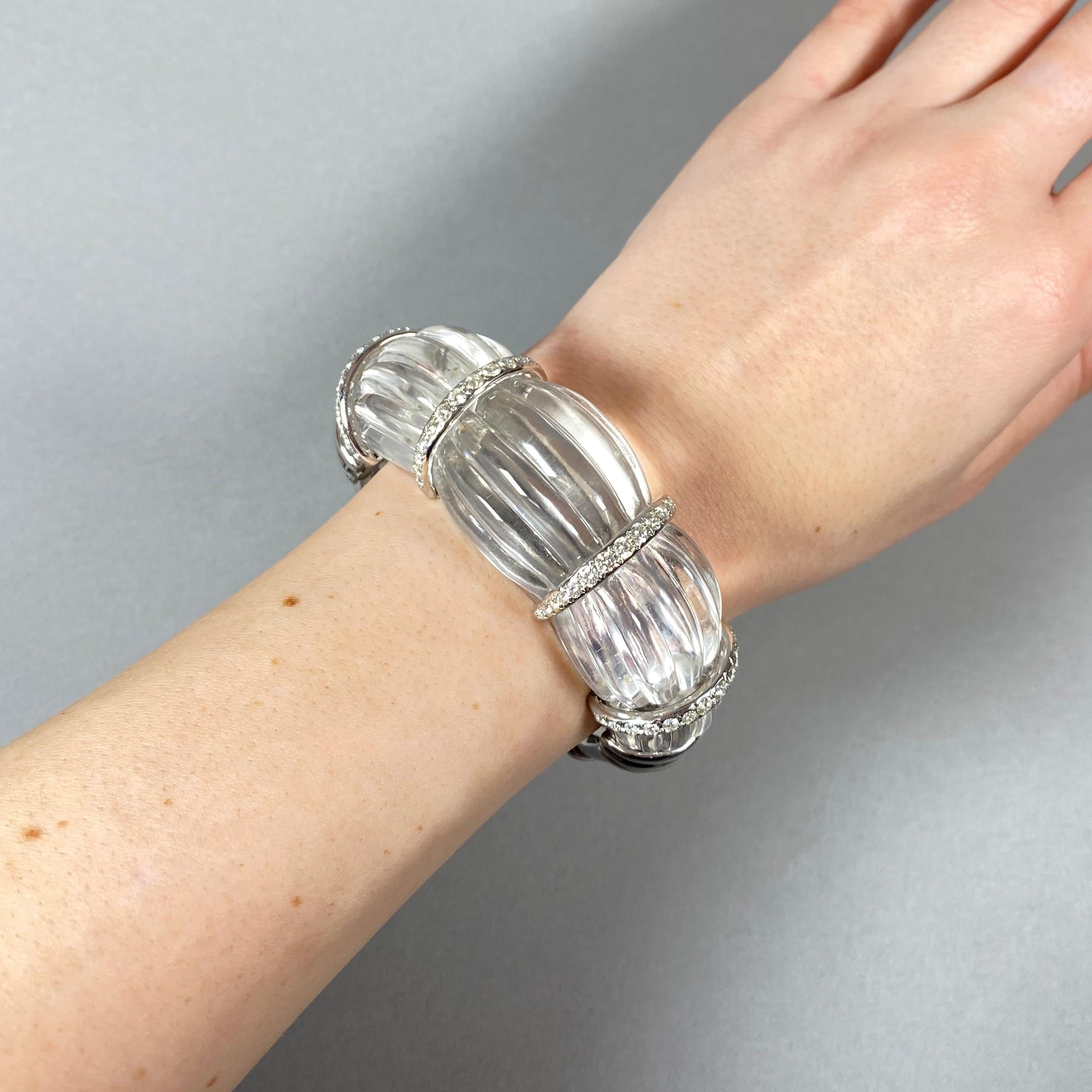 A modern, fluted rock crystal bangle bracelet, carved from one single piece of rock crystal, with four 18ct white gold spacer sections, each set with round brilliant-cut diamonds, weighing an estimated total of 2.50 carats, with 18ct white gold