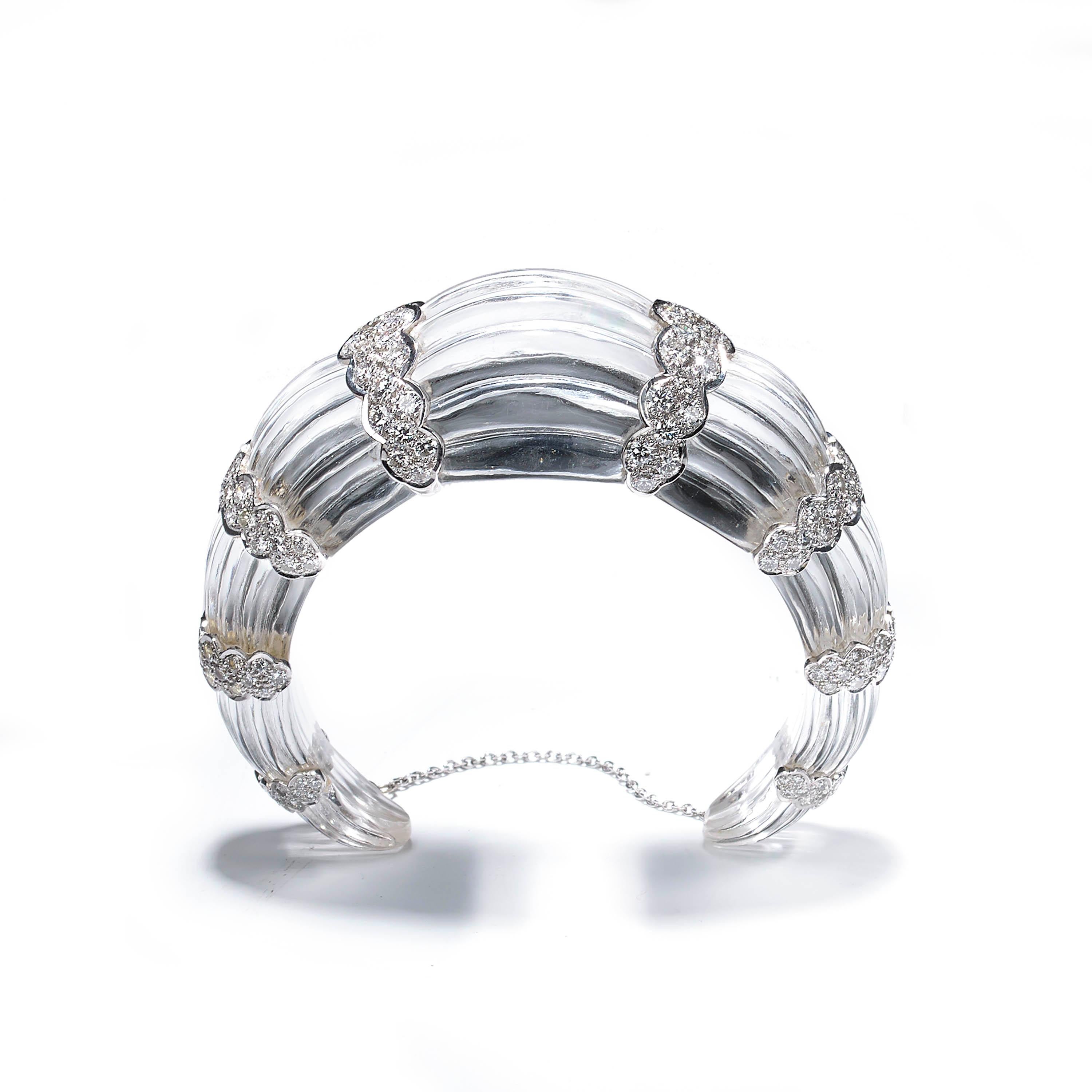 A modern, fluted rock crystal bangle bracelet, carved from one single piece of rock crystal, with eight scalloped 18ct white gold sections, each set with round brilliant-cut diamonds, weighing an estimated total of 7.00 carats. With a white gold