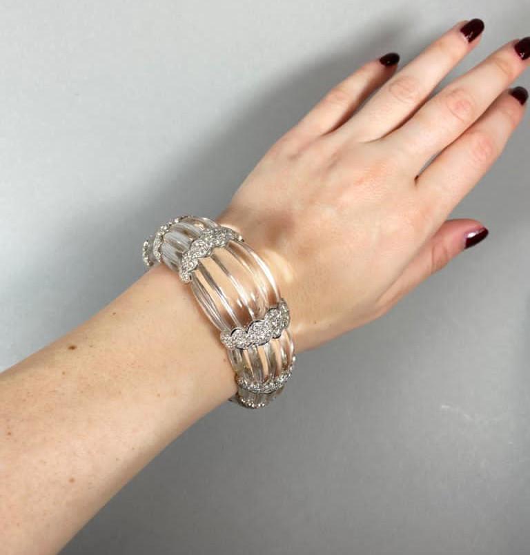 A modern, fluted rock crystal bangle bracelet, carved from one single piece of rock crystal, with eight scalloped 18ct white gold sections, each set with round brilliant-cut diamonds, weighing an estimated total of 7.00 carats. With a white gold